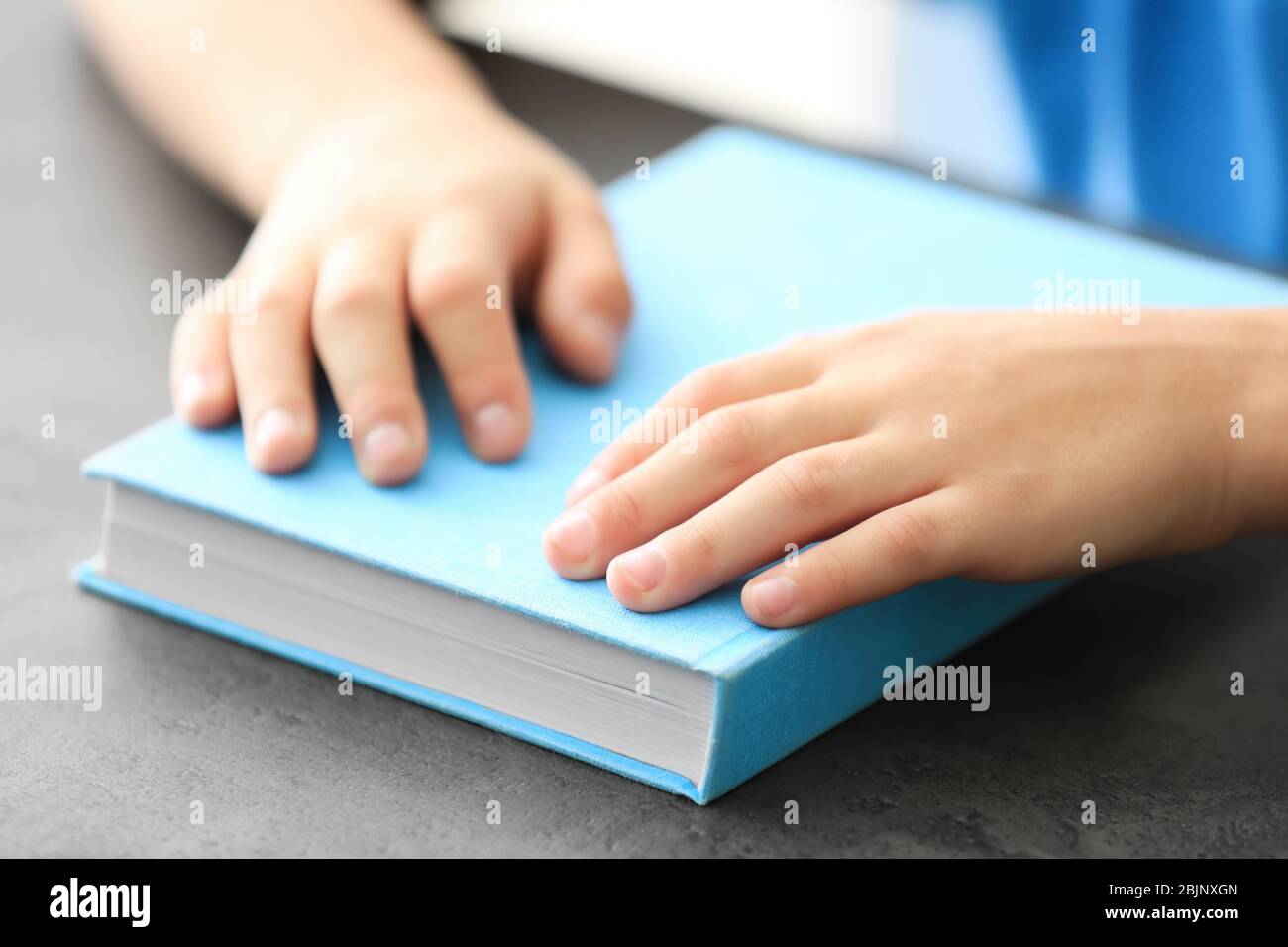 Cute little child with book at home, closeup Stock Photo - Alamy