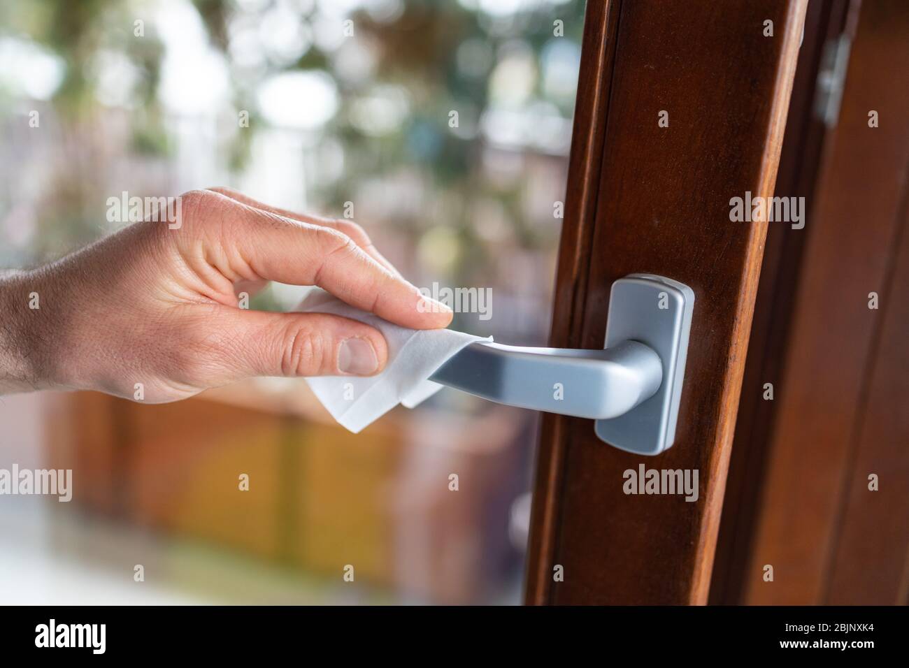 Male hands wiping door handle with disinfectant wipe Stock Photo Alamy