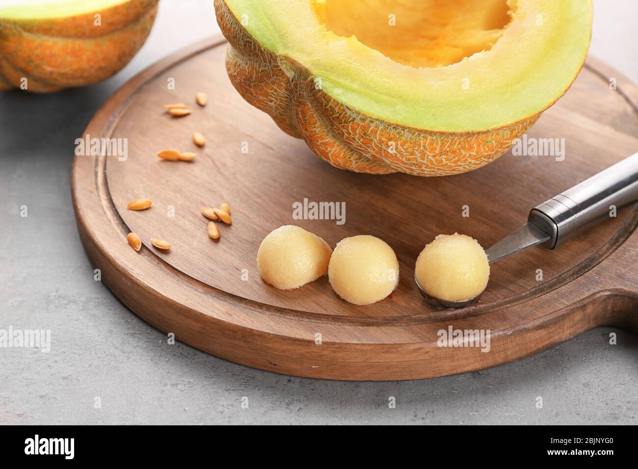 https://c8.alamy.com/comp/2BJNYG0/board-with-melon-and-tasty-balls-on-table-2BJNYG0.jpg