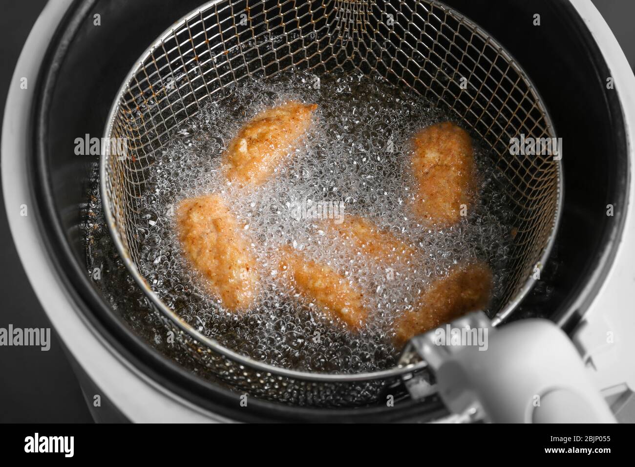 Salmon croquettes deep frying in basket, closeup Stock Photo Alamy