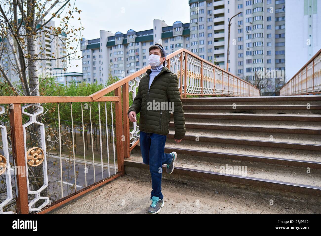 Picture of teen boy walks down the street during the day, a pedestrian walkway and ...