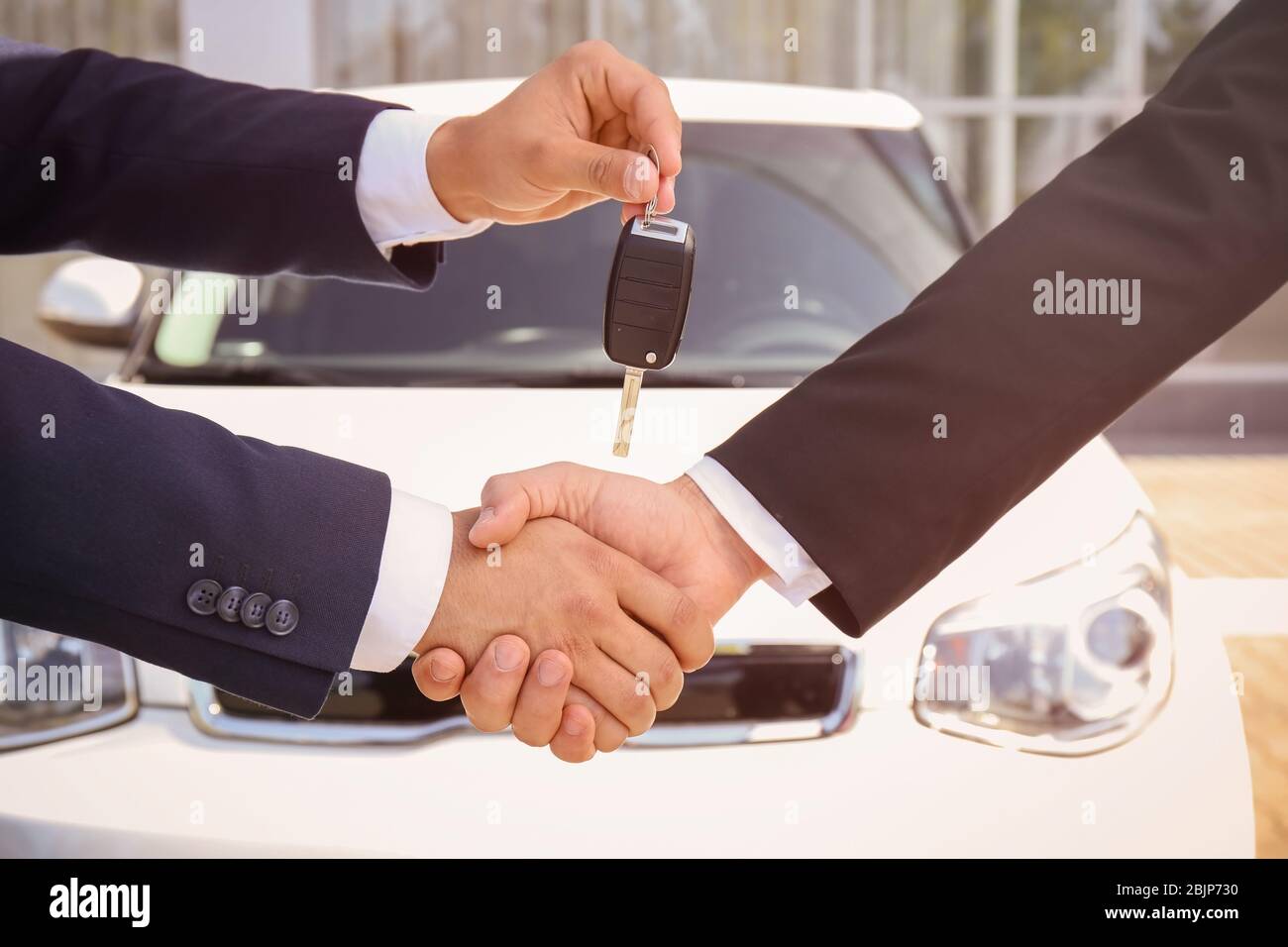Salesman giving car key to customer outdoors Stock Photo - Alamy
