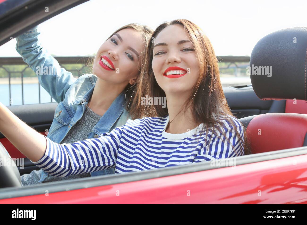 Two beautiful young women in cabriolet outdoors Stock Photo - Alamy