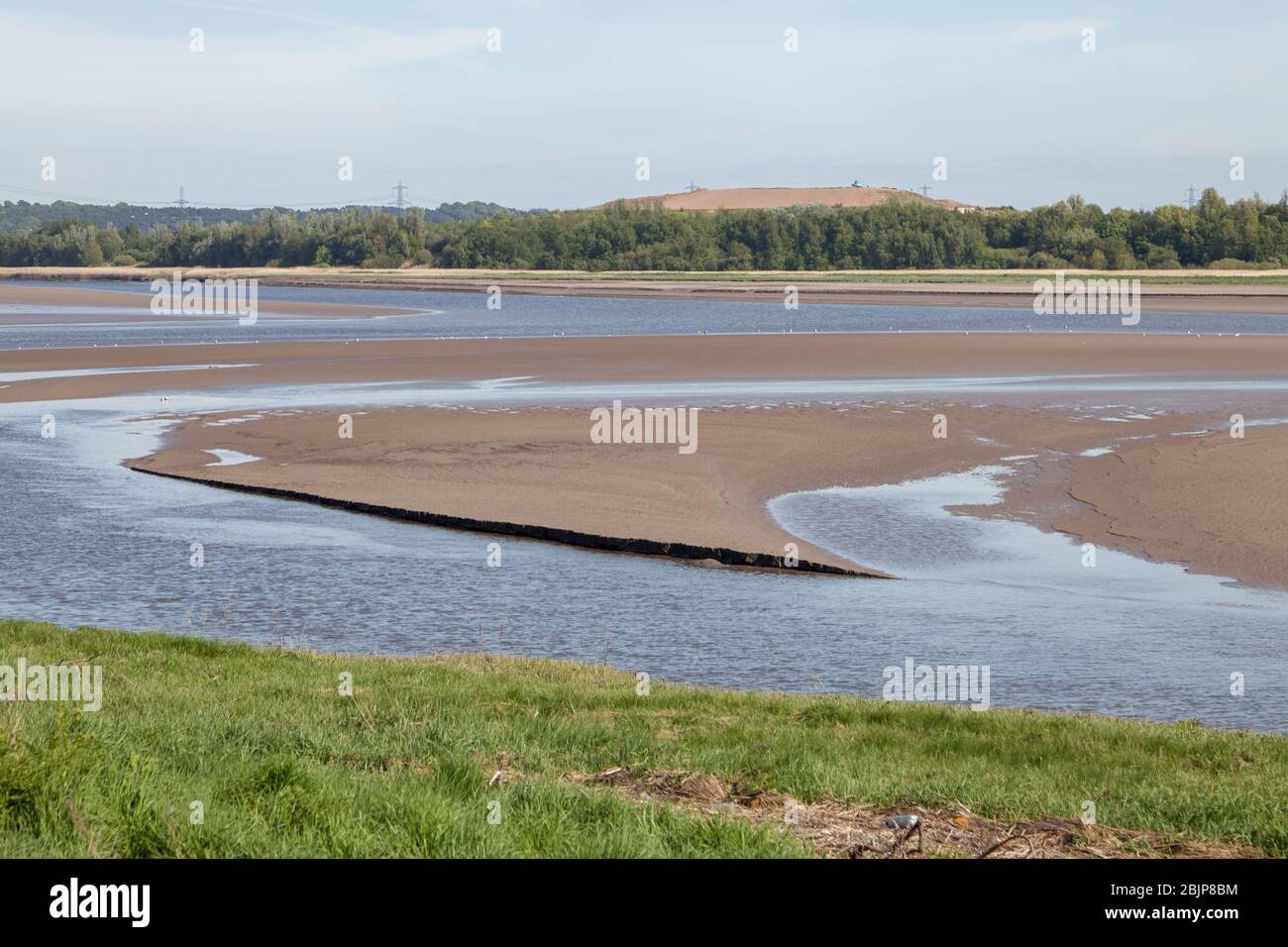 Saltmarsh and sandbanks at low tide on the Mersey Estuary viewed from Widnes Warth; an area of walkways and bird hides near Widnes Stock Photo