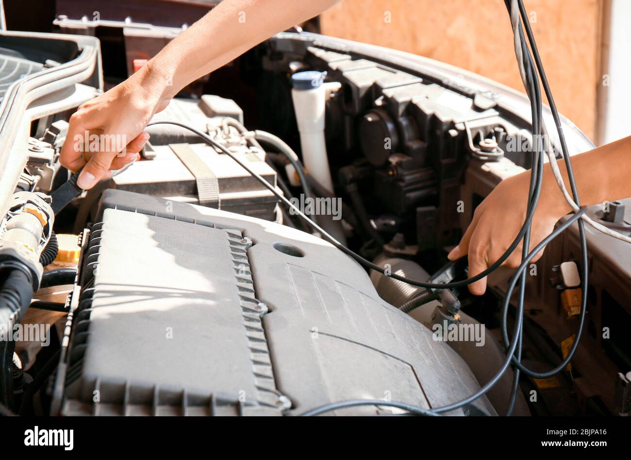 Young female mechanic repairing car in body shop Stock Photo