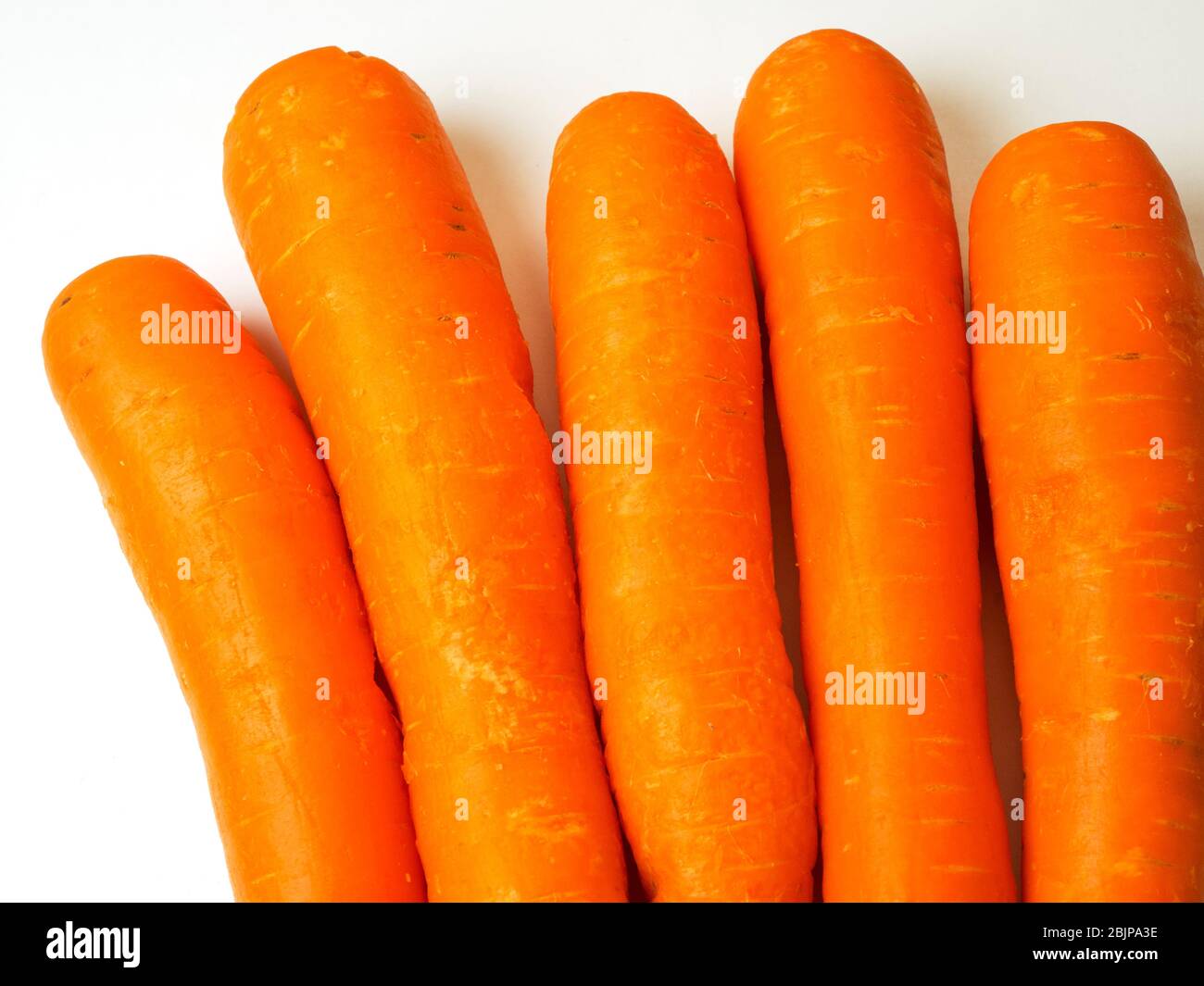 Five fresh orange carrots on a white background Stock Photo