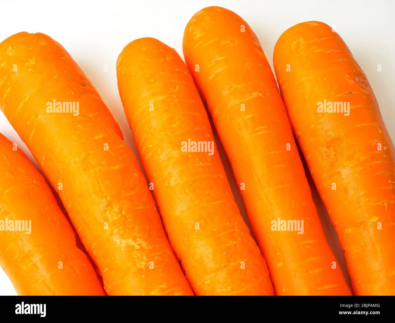 Five fresh orange carrots on a white background Stock Photo