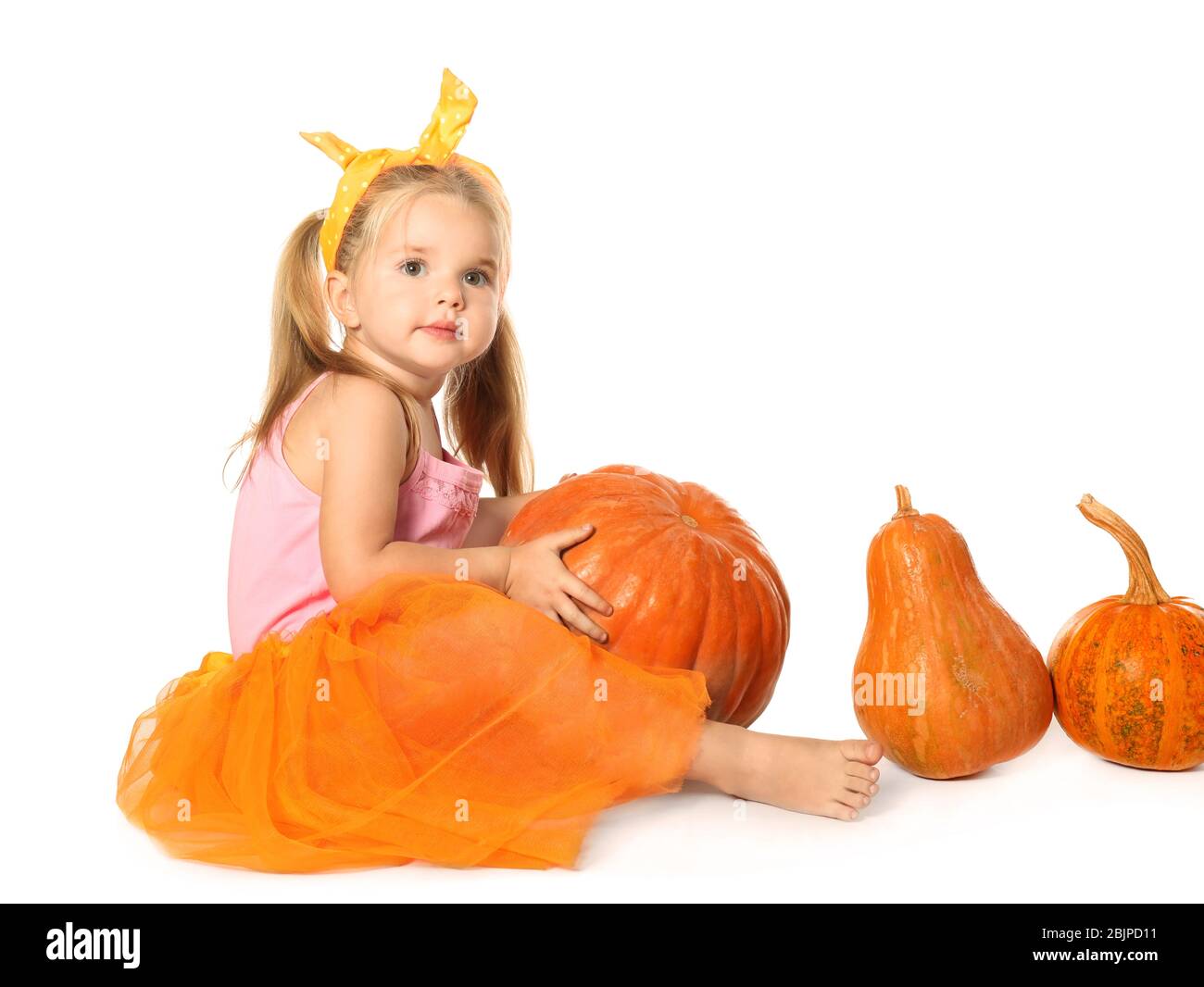Adorable little girl with pumpkins on white background Stock Photo - Alamy
