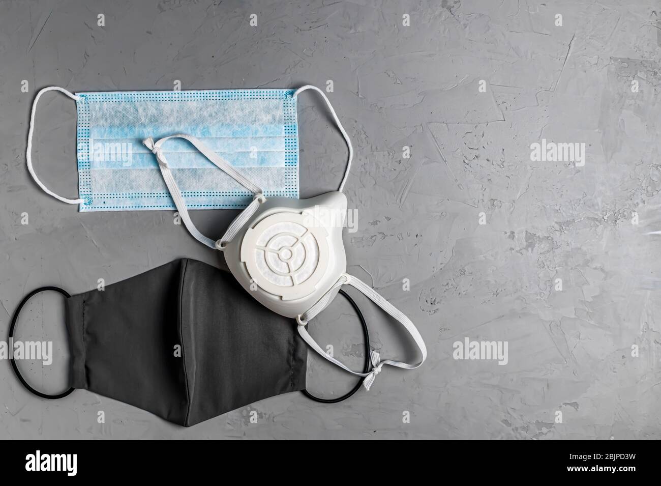different protective masks on a gray concrete background with copy space Stock Photo