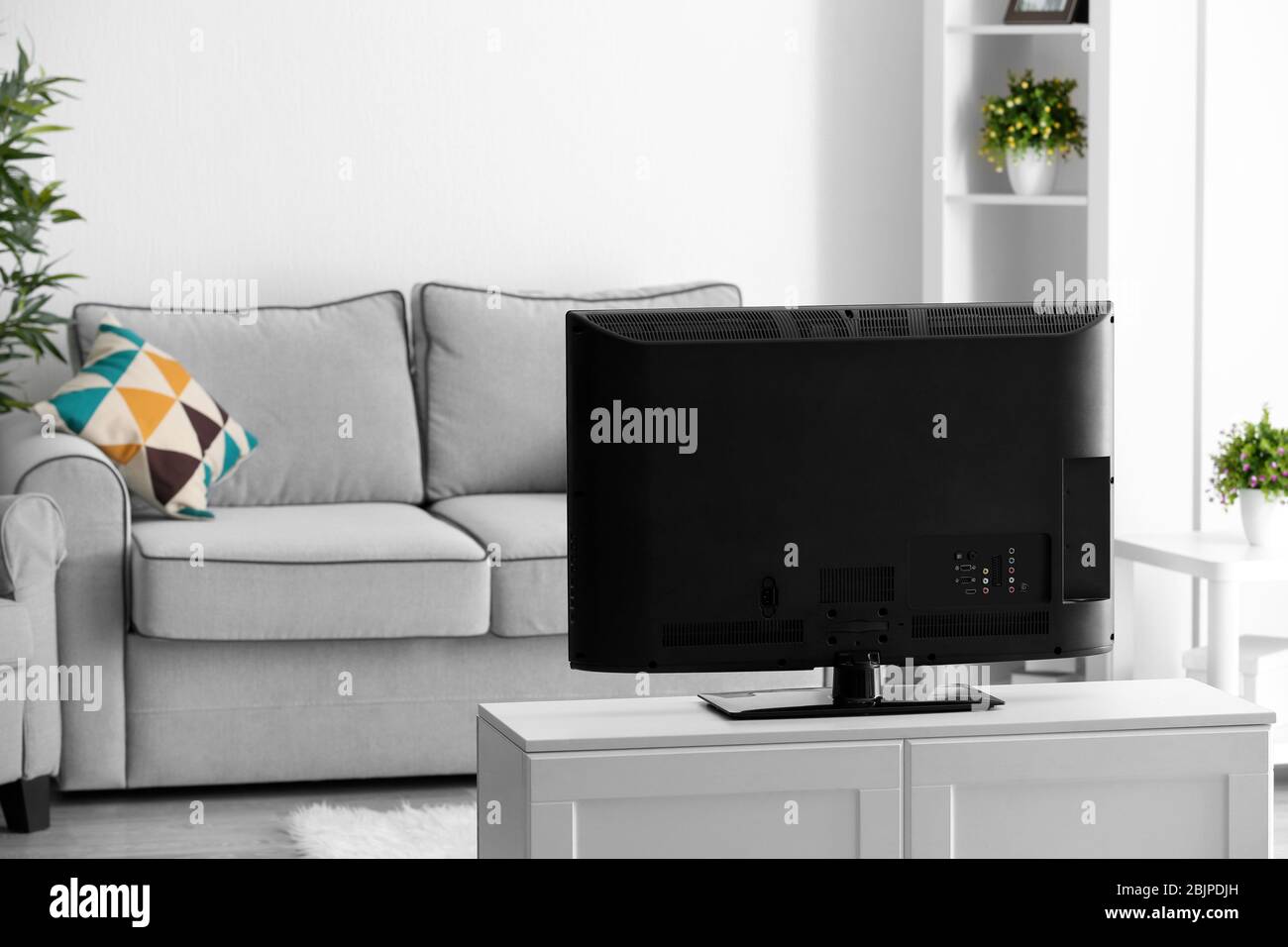 Back view of modern TV set on stand in living room Stock Photo - Alamy