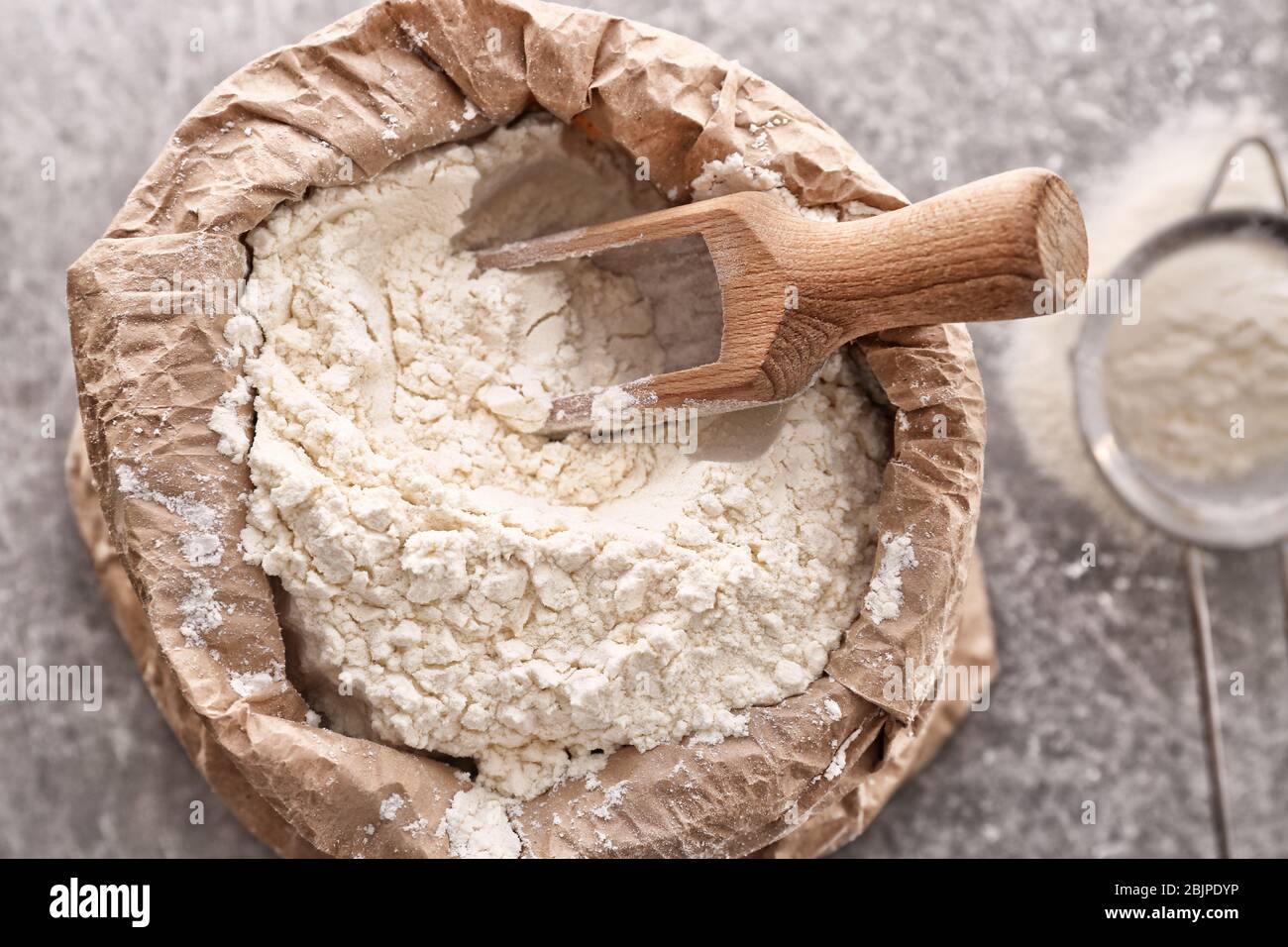 Paper bag and scoop with flour, closeup Stock Photo Alamy