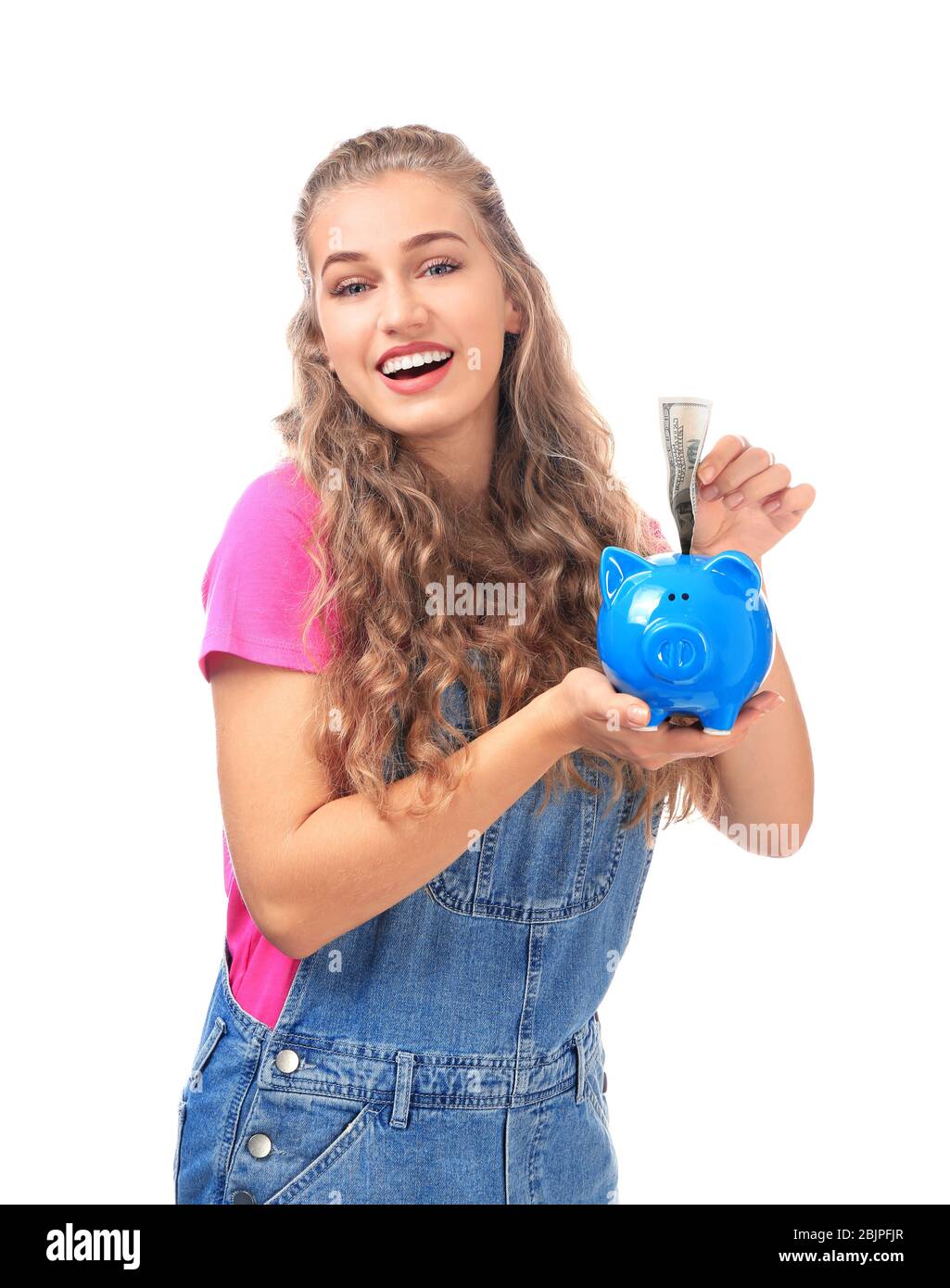 Young woman putting money into piggy bank on white background Stock ...