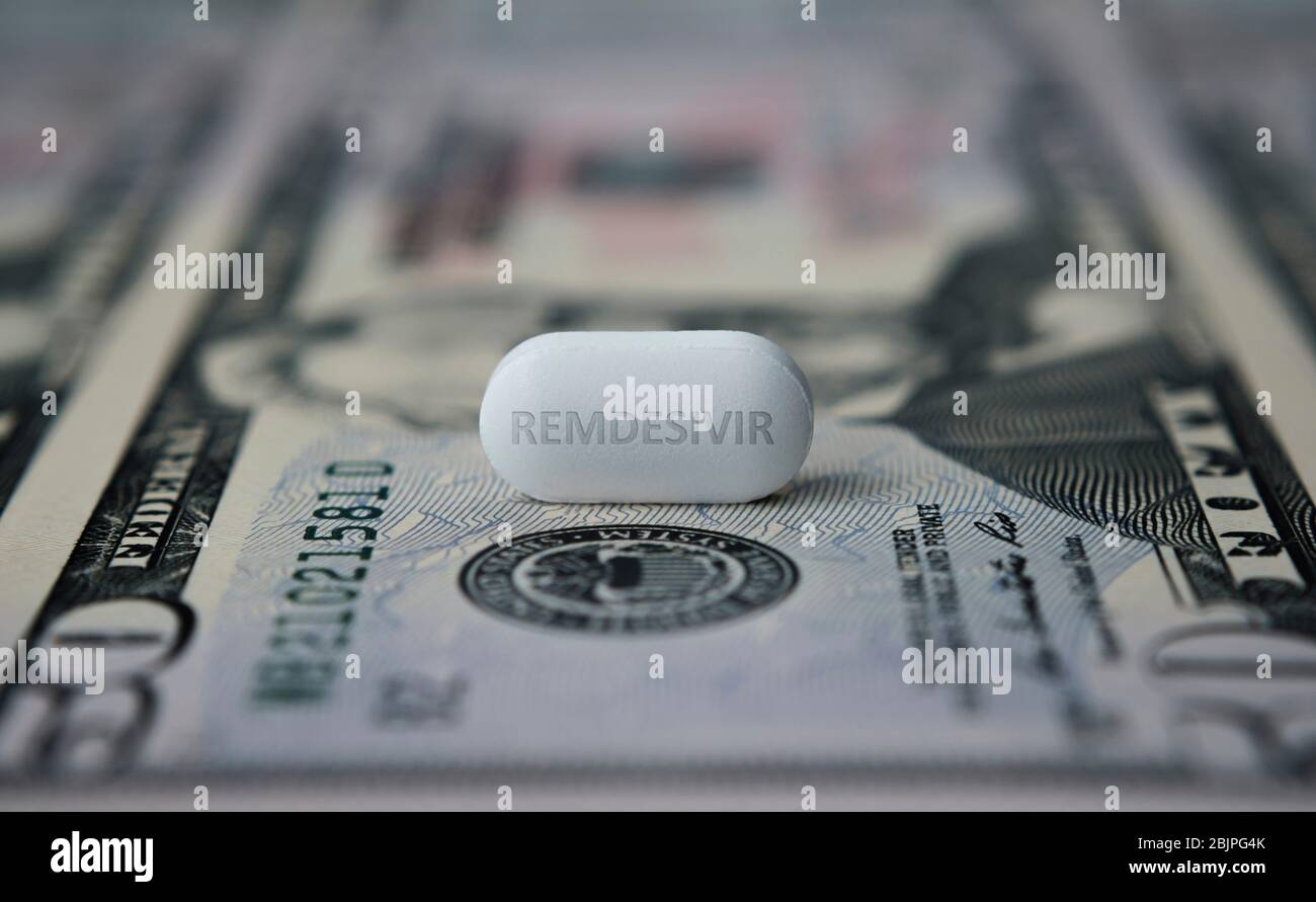 Remdesivir pill on top of 50 dollar banknote. Concept photo. Illustrative for potential profit from COVID-19 treatment drug. Selective focus, shallow Stock Photo