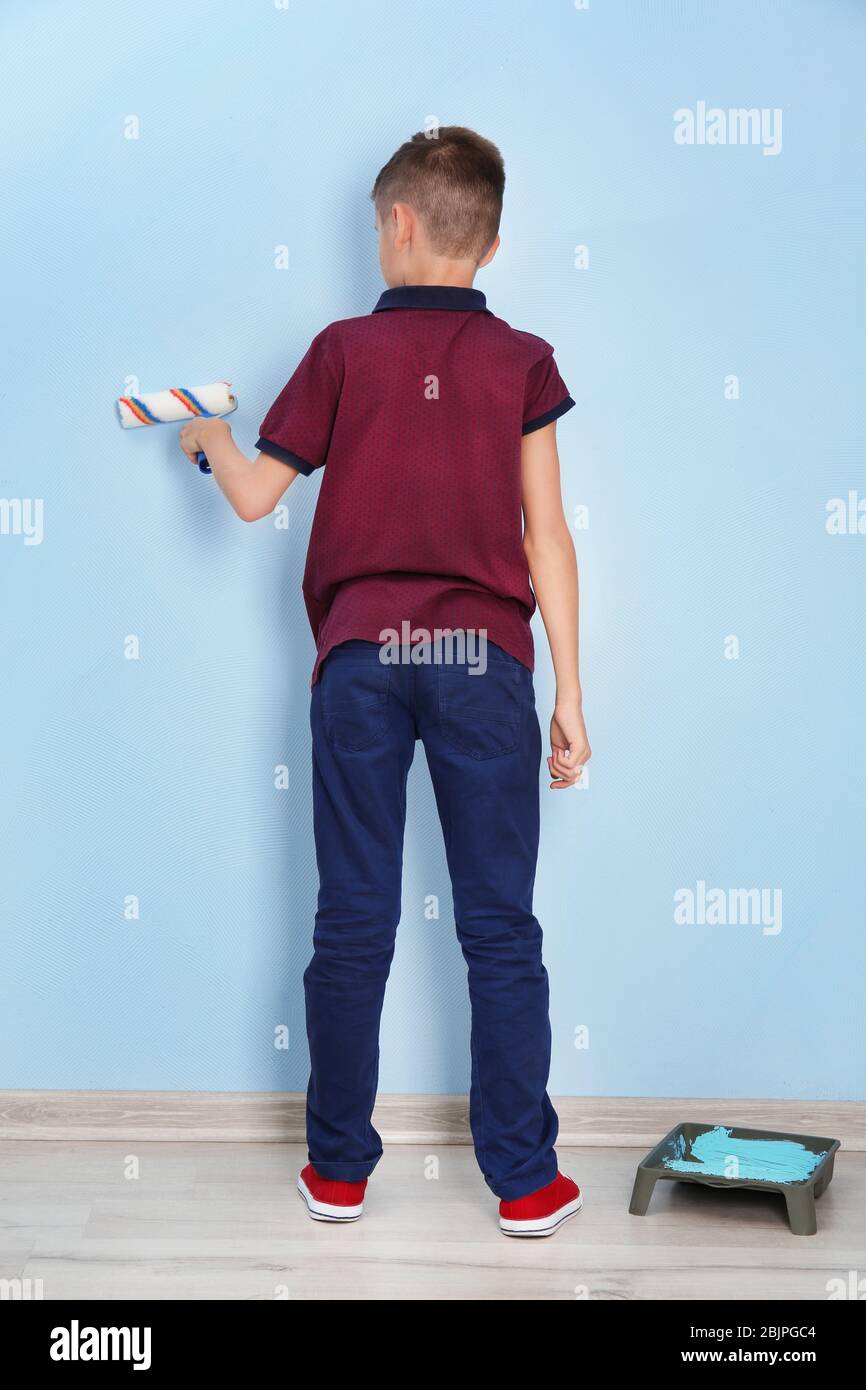 Cute little boy painting wall in room Stock Photo Alamy