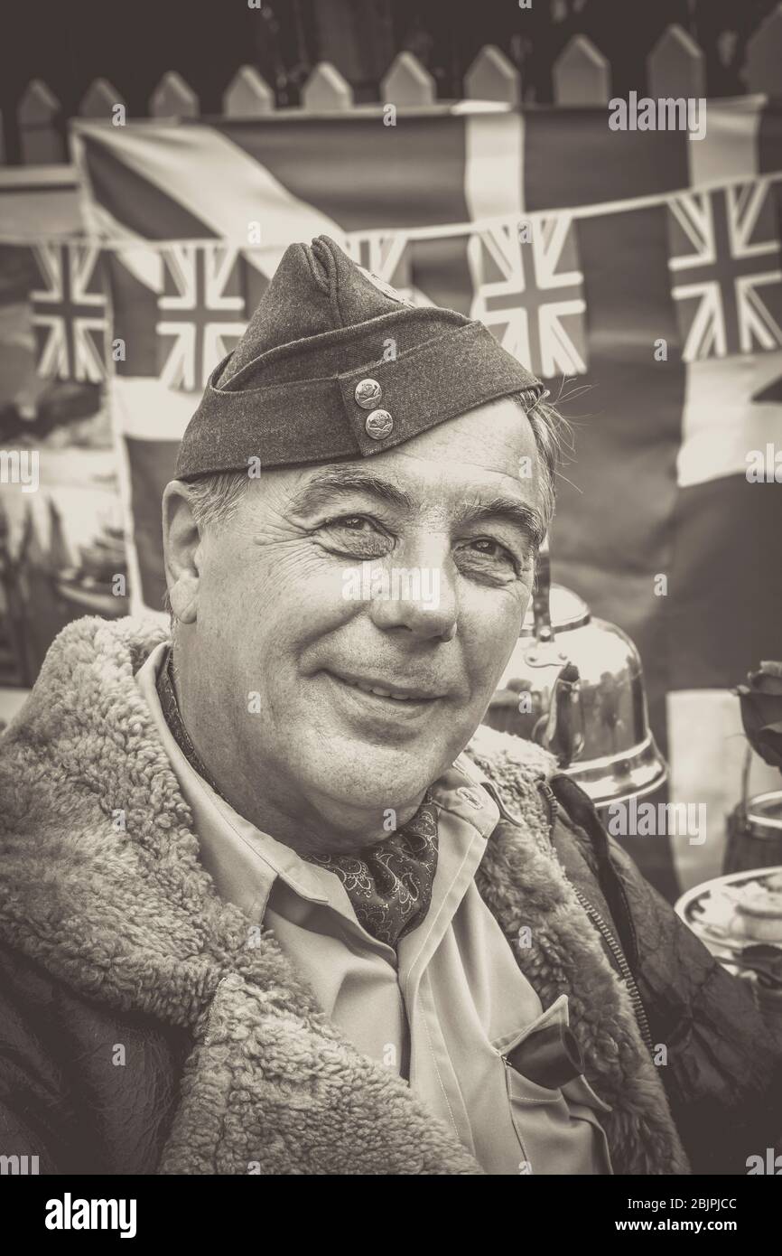 Monochrome close up front portrait of smiling 1940 man in RAF uniform & leather flying jacket, 1940s wartime WWII summer event UK. We'll meet again. Stock Photo