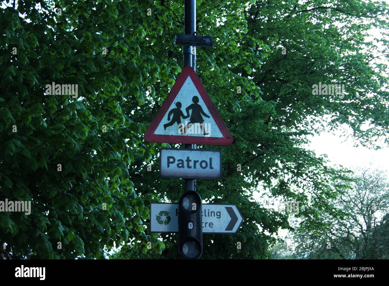 Red triangle patrol road sign in front of a tree in Manchester, England Stock Photo