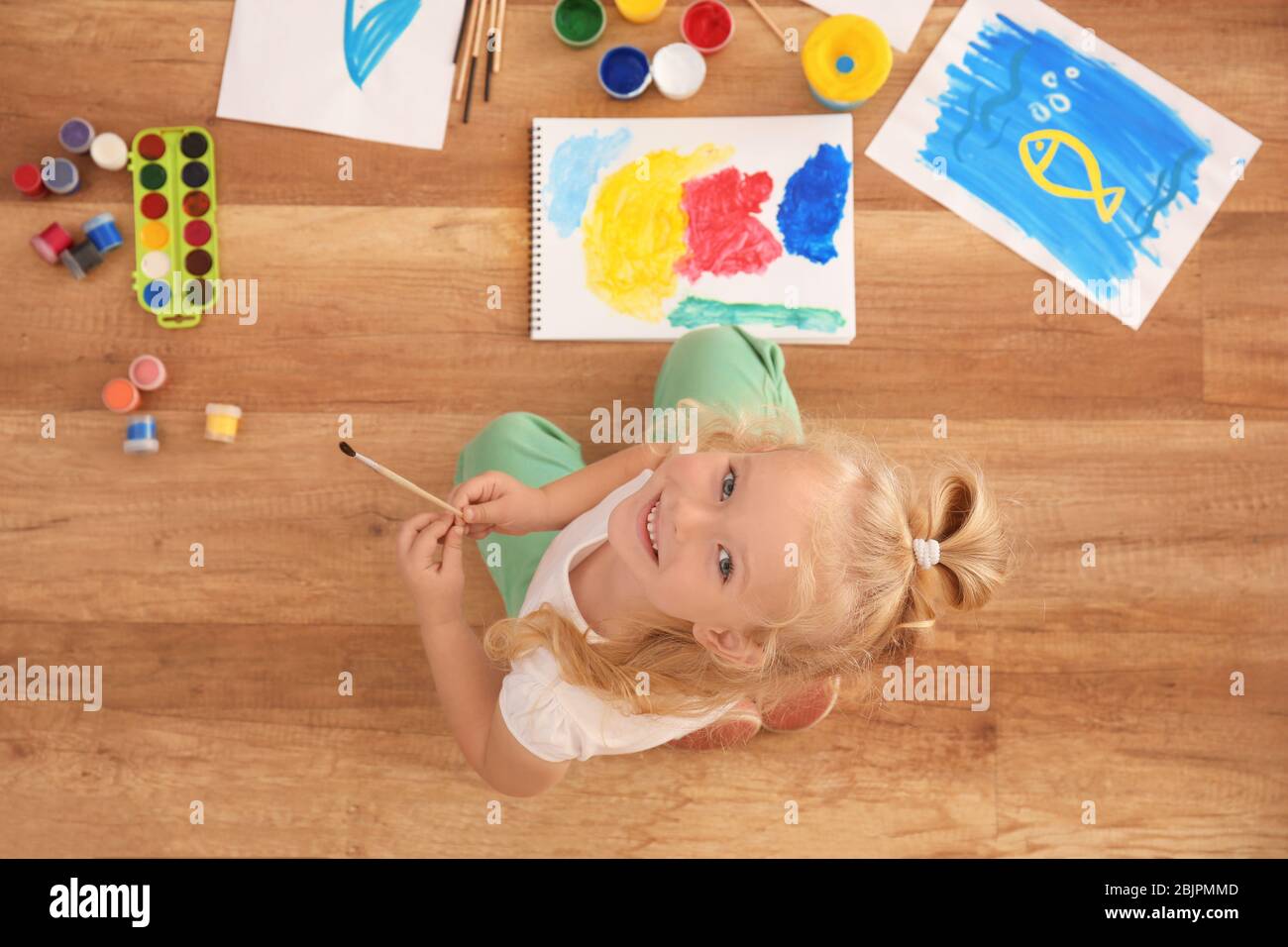 Cute girl painting picture on sheet of paper, indoors Stock Photo - Alamy