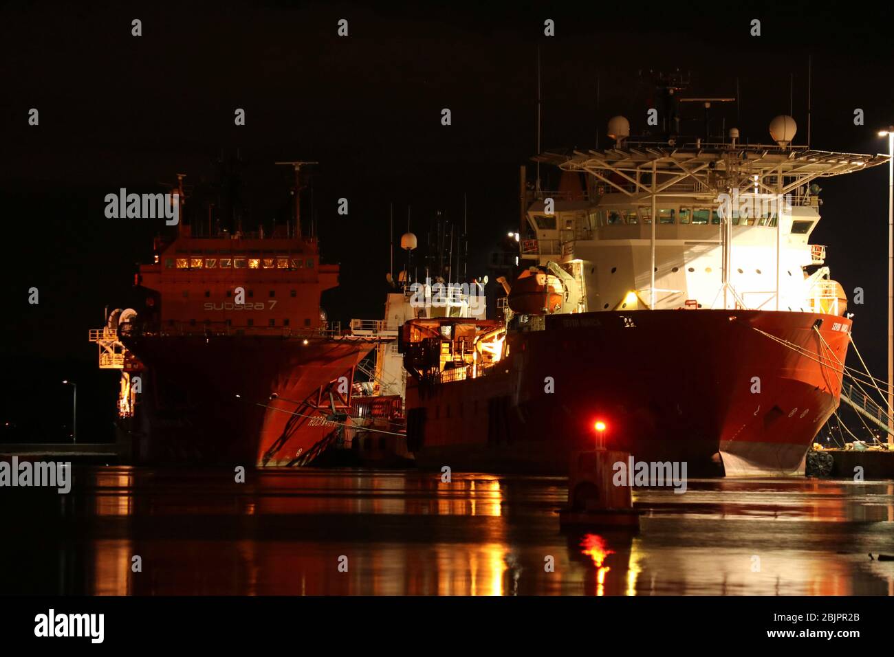 Offshore pipe-layer 'Seven Navica' and offshore supply ship 'Rockwater 1' in Leith Docks (night scene), Edinburgh, Scotland Stock Photo