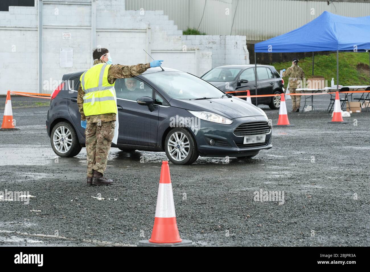 Hereford, Herefordshire UK - Thursday 30th April 2020 - As rain falls Army personnel man a pop-up Coronavirus testing site in a car park in Hereford to provide Covid-19 swab tests as the Government strives to reach 100,000 tests per day by the end of April ( today ). Photo Steven May / Alamy Live News Stock Photo