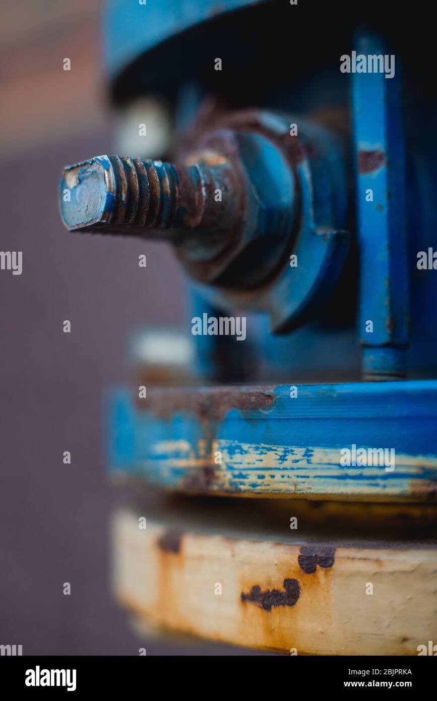 Old industrial screw nut rust on a blue pipe. Selective focus, macro photography Stock Photo
