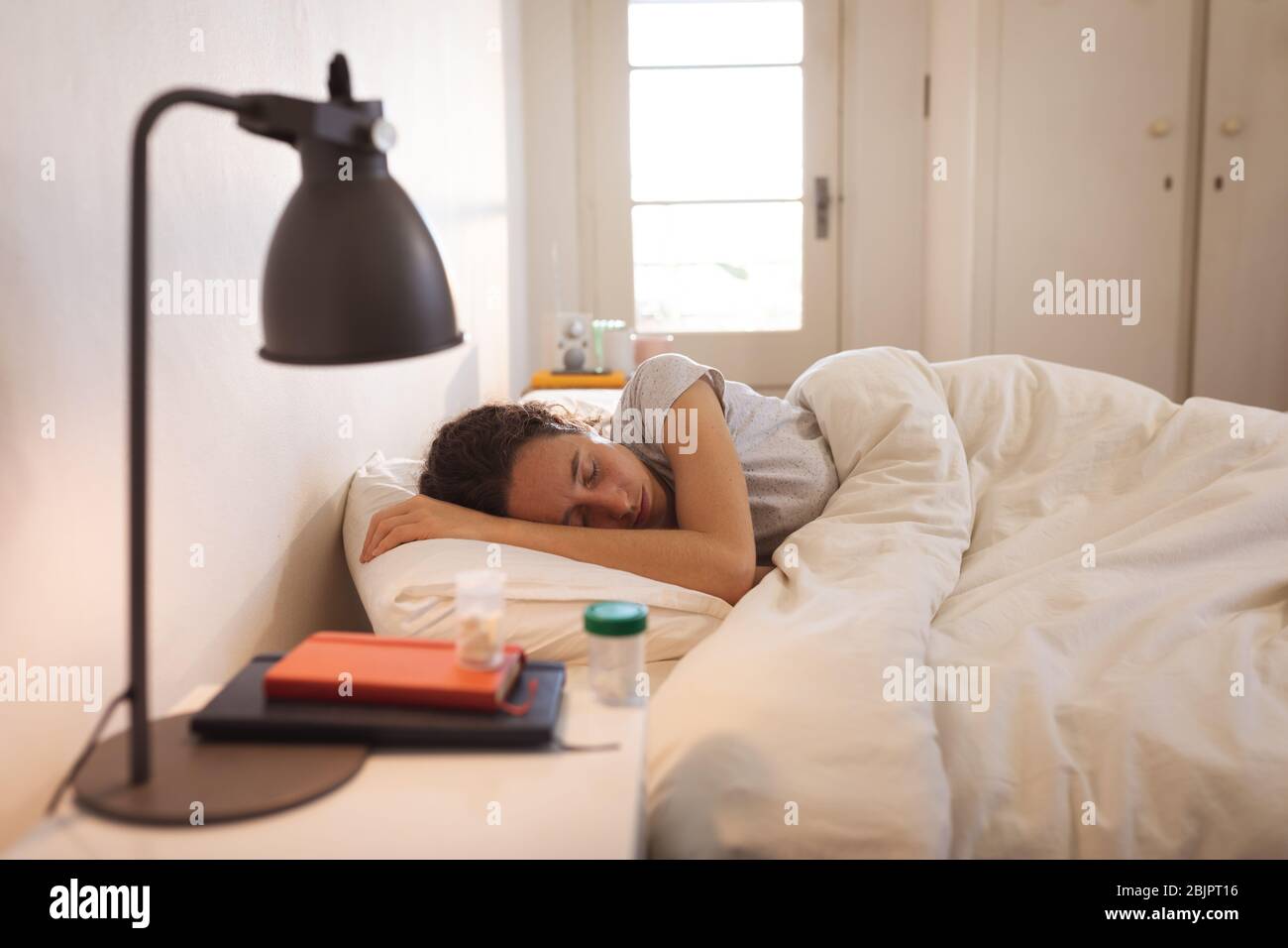 Sick Caucasian woman self isolating and social distancing in quarantine lockdown during coronavirus Stock Photo