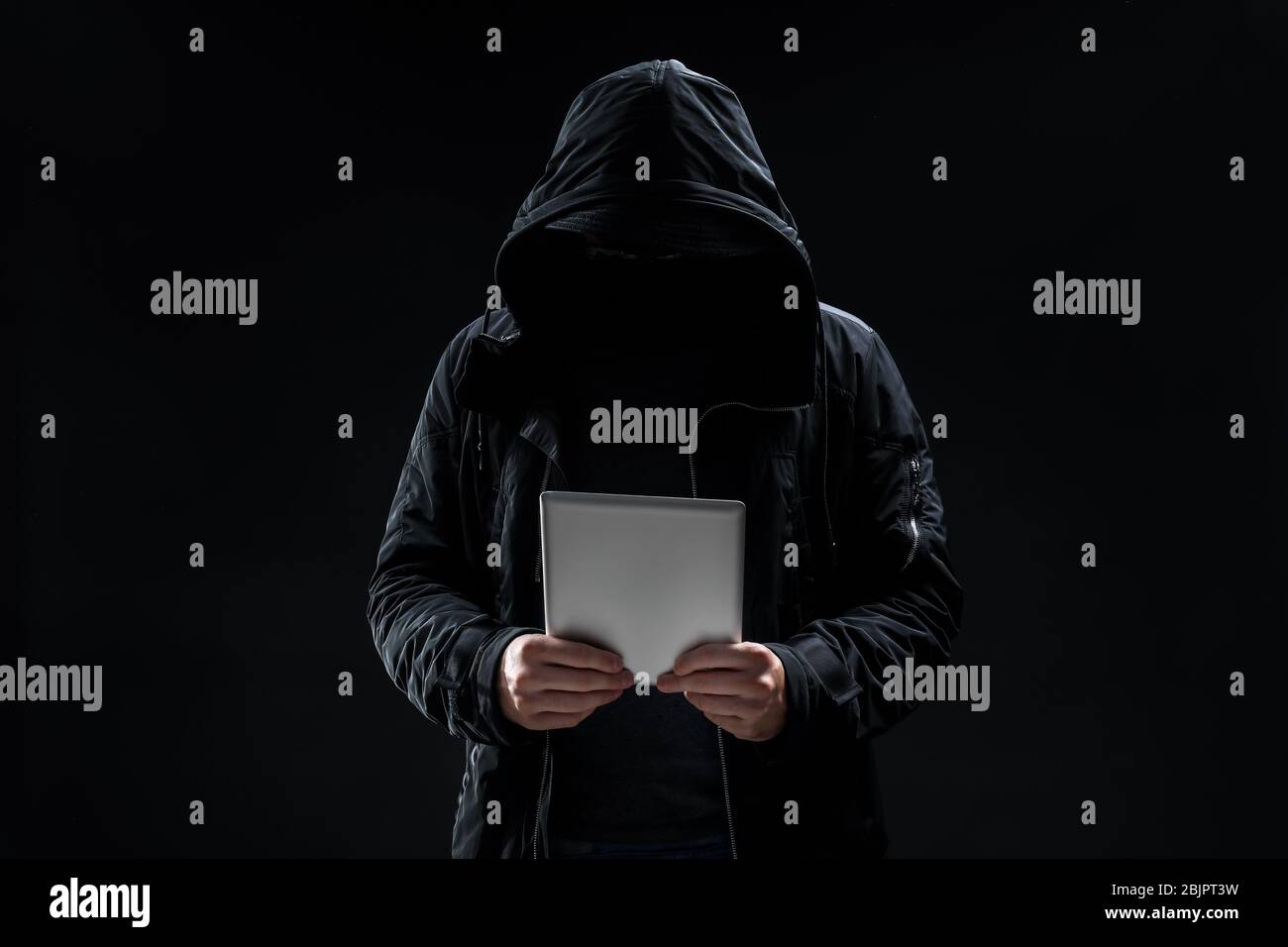 Hacker with tablet on dark background Stock Photo