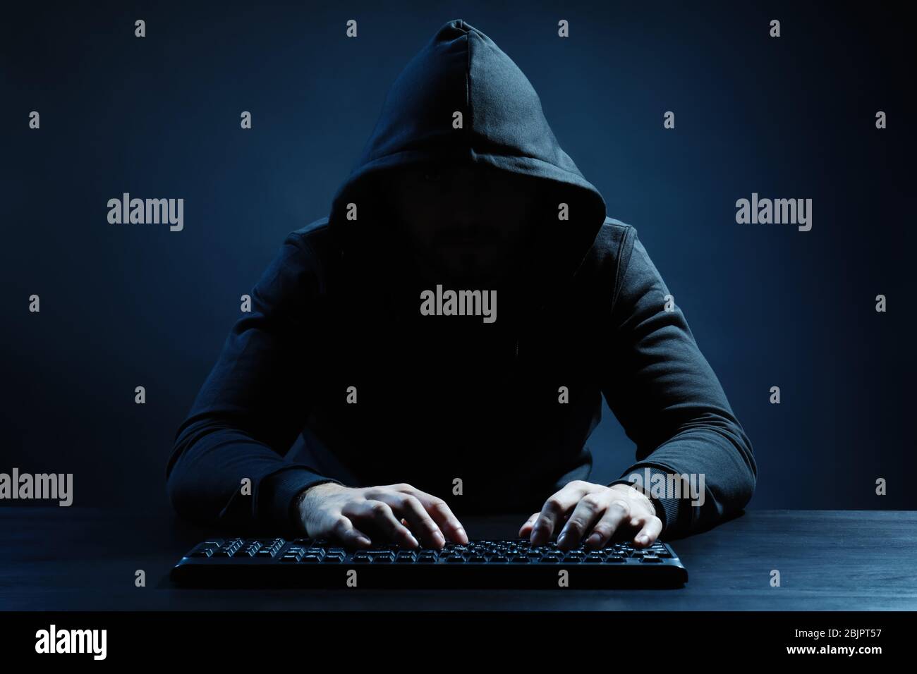 Hacker using keyboard on dark background Stock Photo