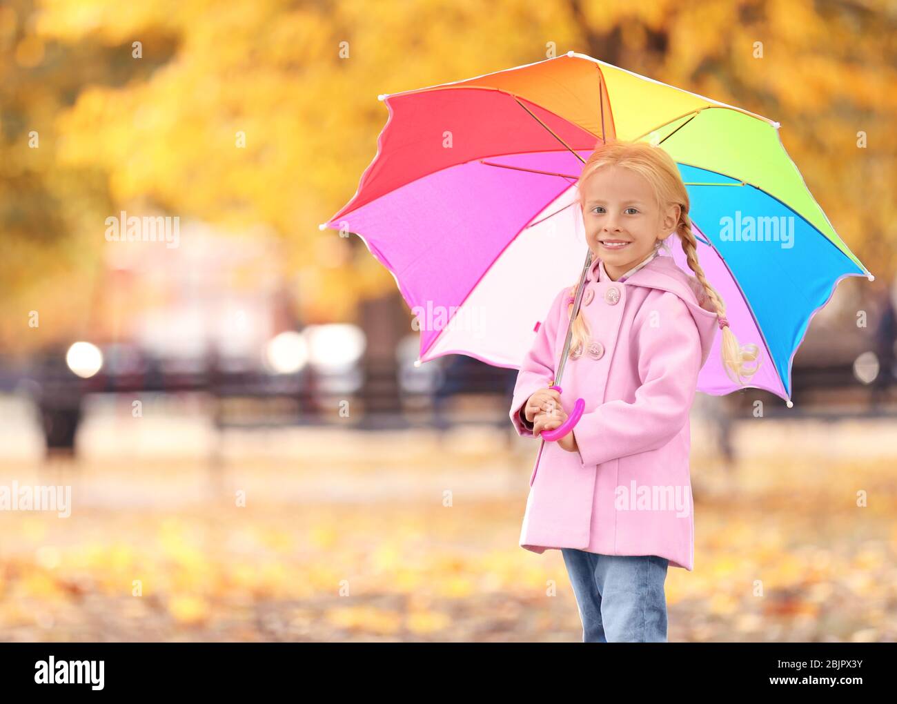 Cute little girl with rainbow umbrella in autumn park Stock Photo - Alamy