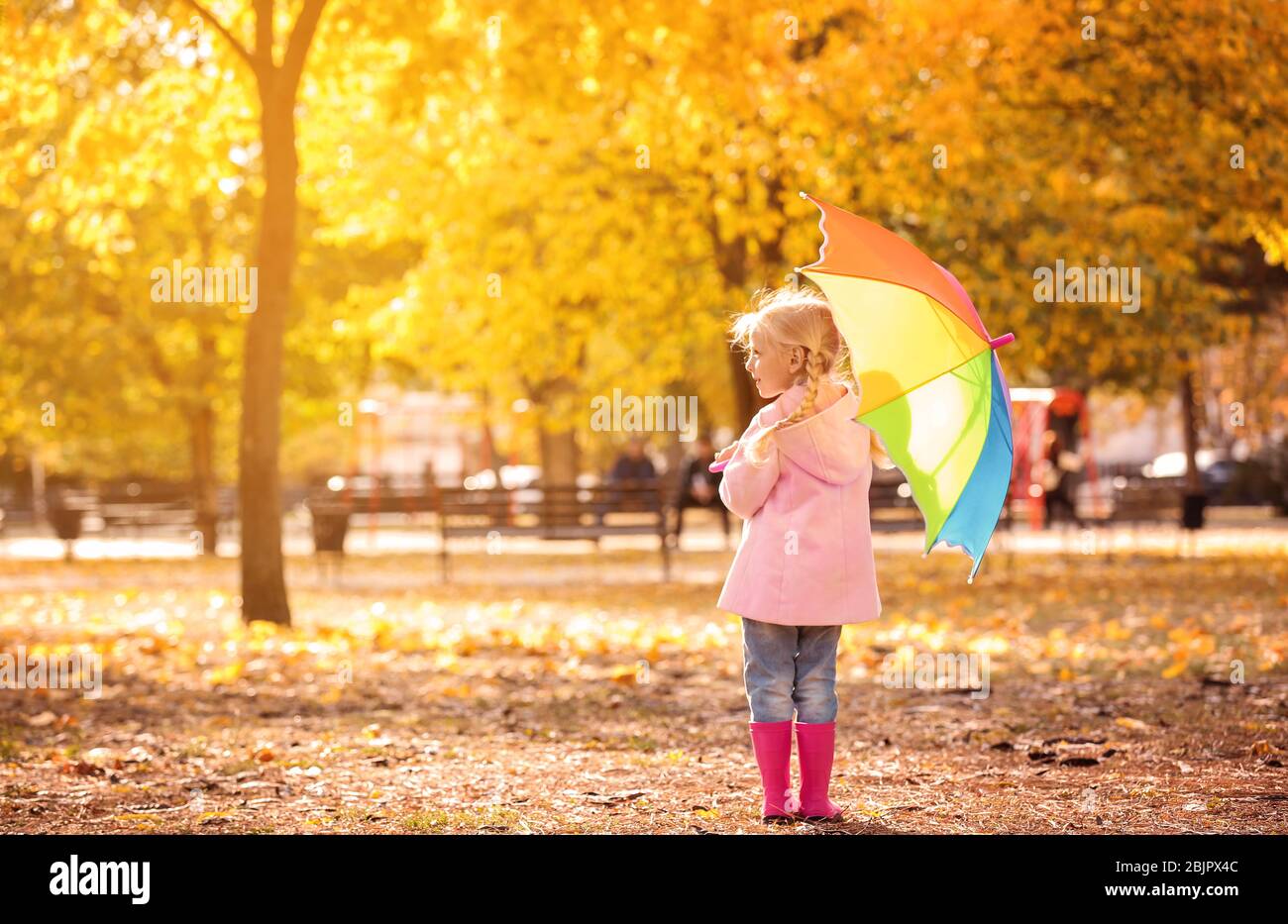 Little girl with rainbow umbrella in autumn park Stock Photo - Alamy