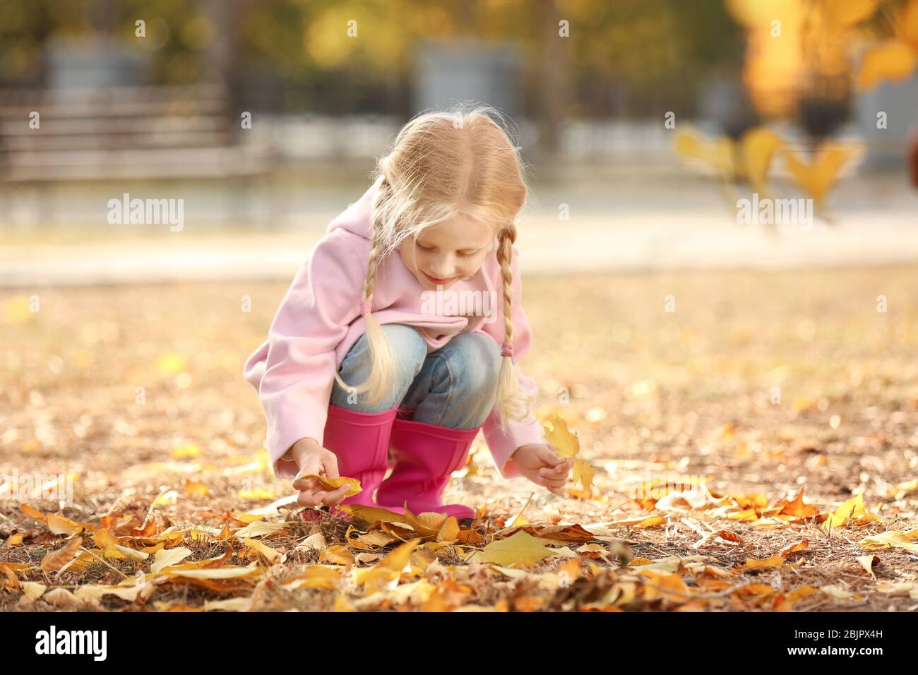 Cute little girl in autumn park Stock Photo - Alamy