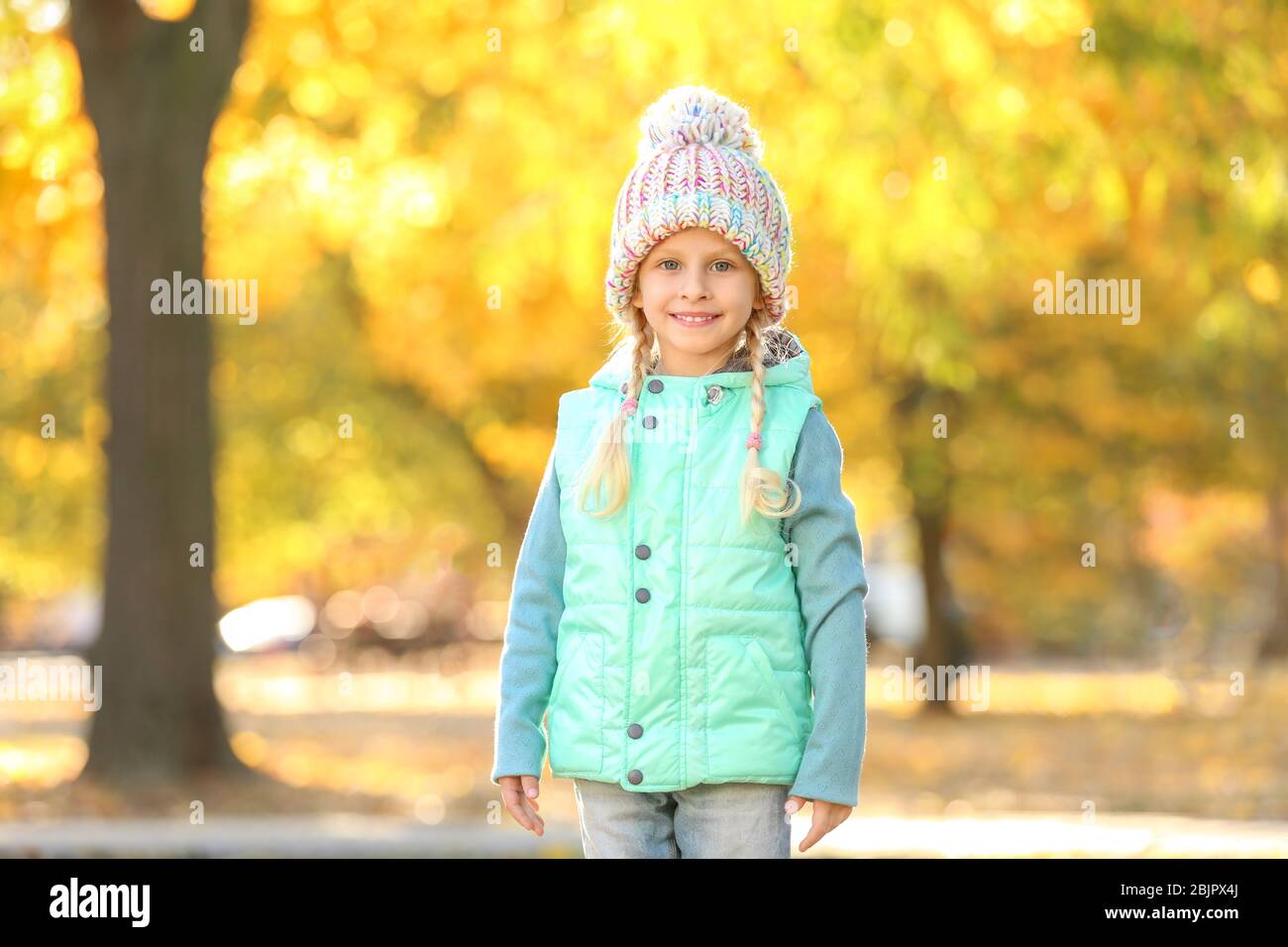 Cute little girl in autumn park Stock Photo - Alamy