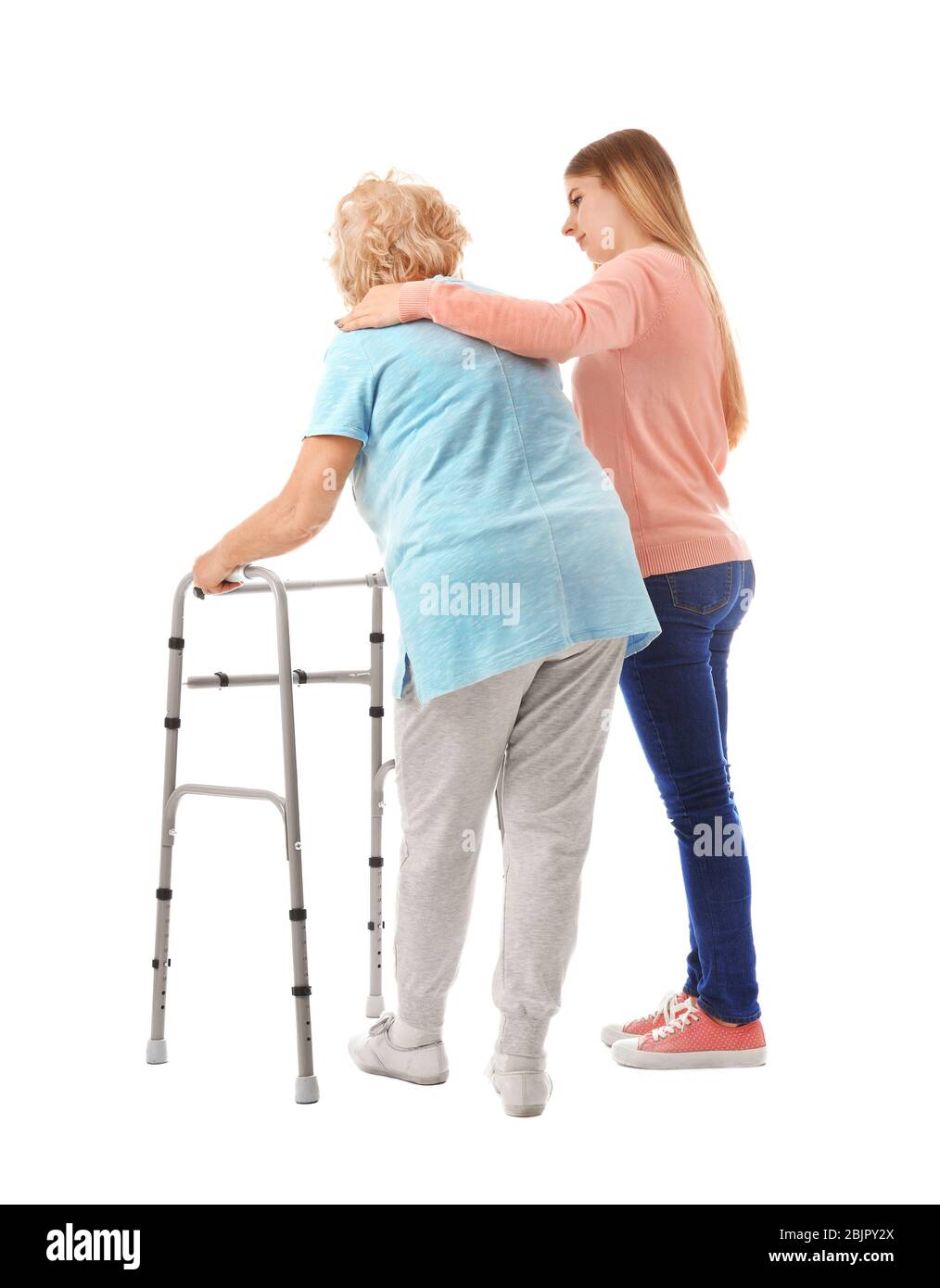 Young woman and her elderly grandmother with walking frame on white ...