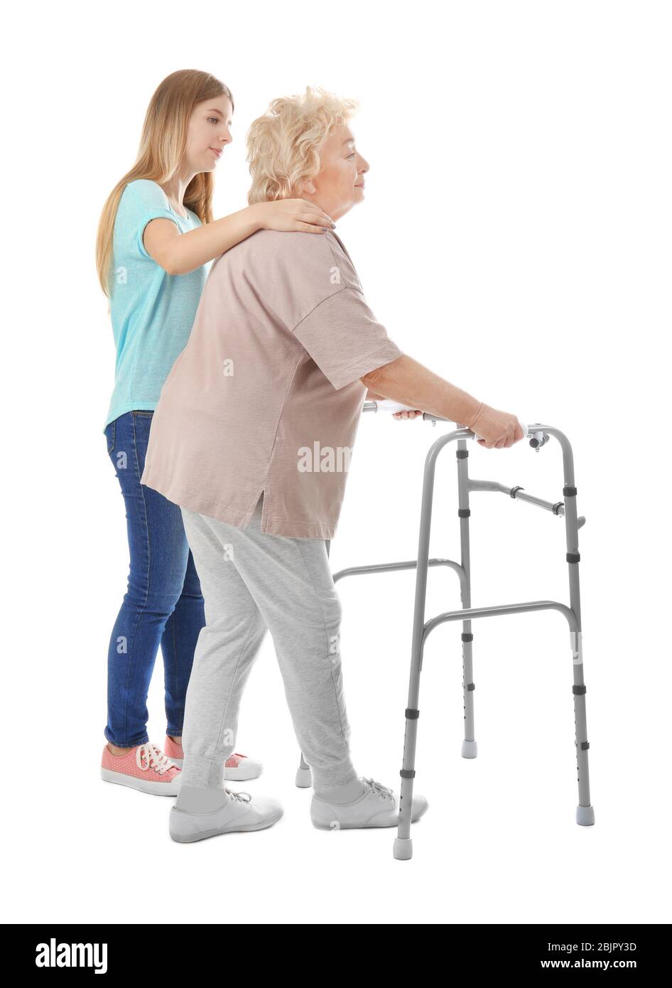Young woman and her elderly grandmother with walking frame on white ...