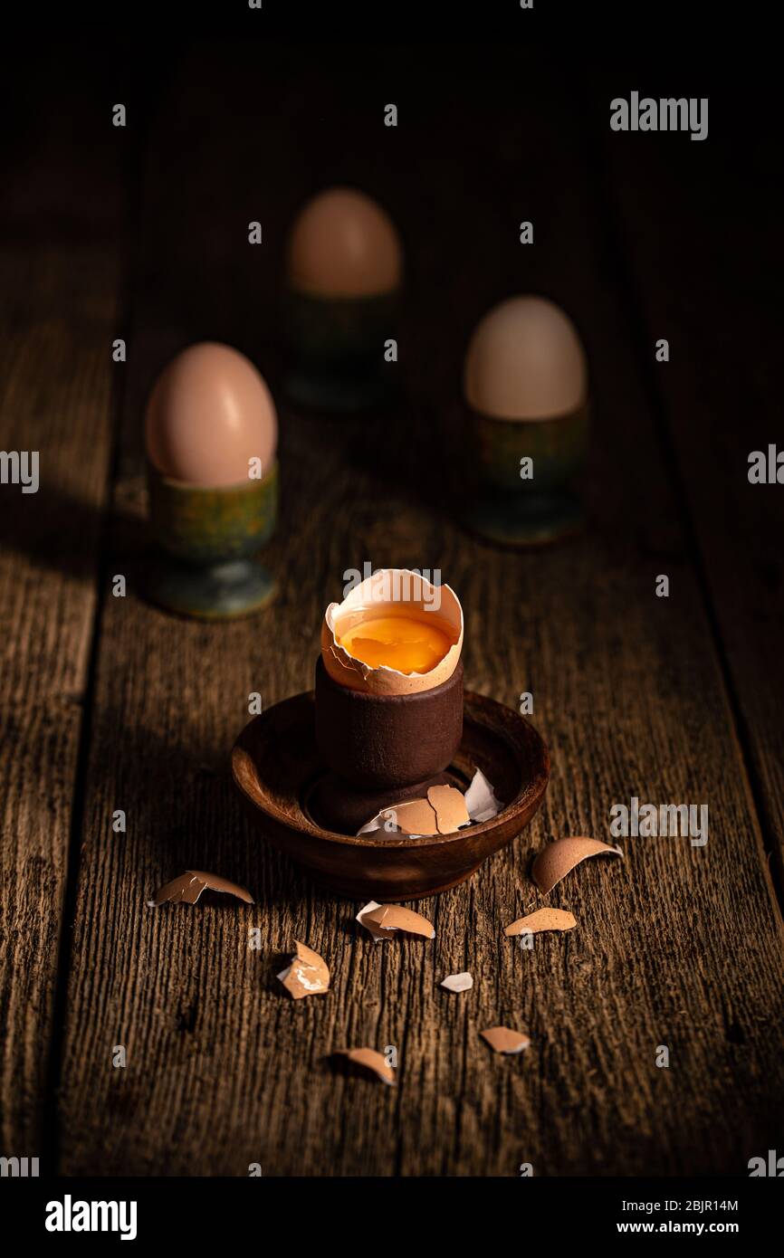 Fresh brown eggs on rustic table. Broken egg with yolk. Stock Photo