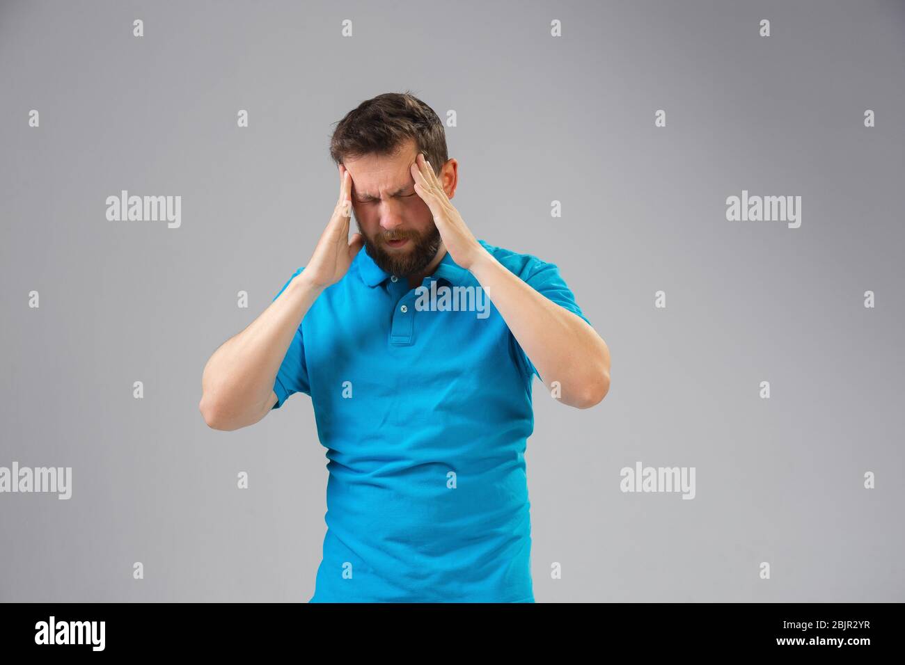 Young caucasian man suffers from headache, feels sick, ill and weakness