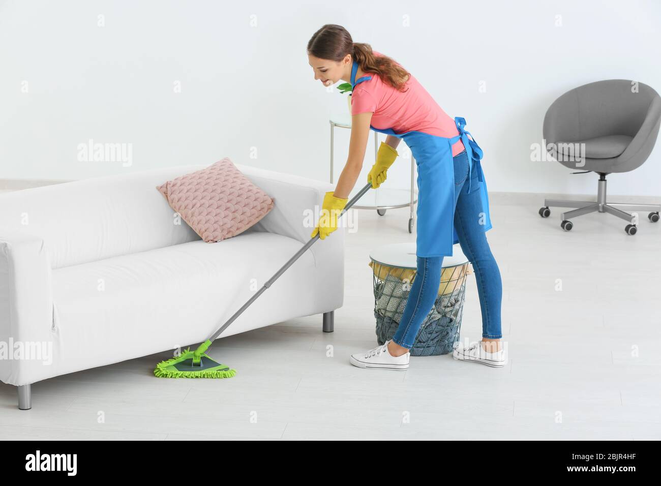 Young woman mopping floor at home Stock Photo