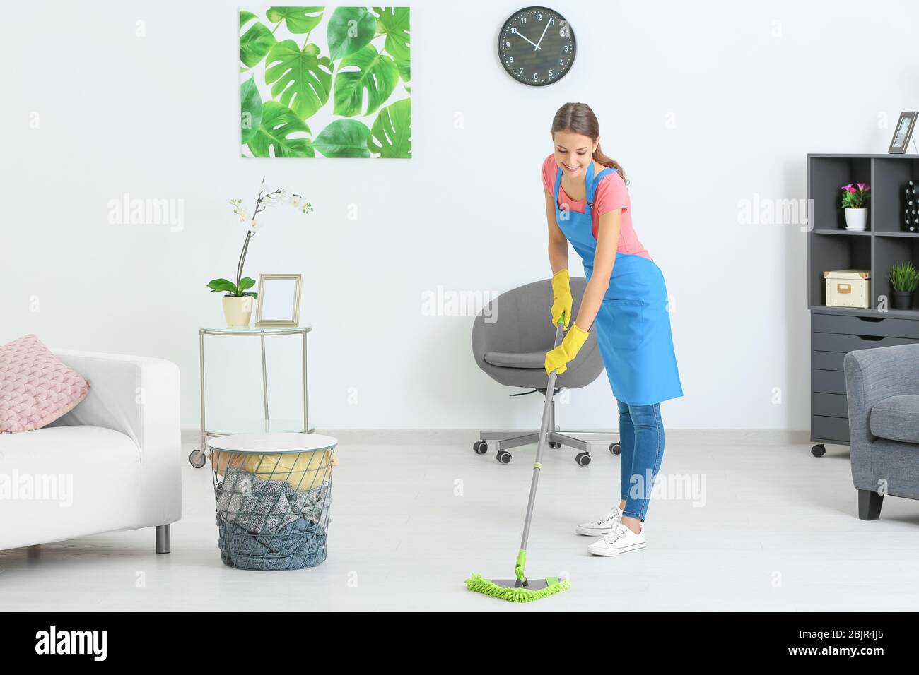 Young woman mopping floor at home Stock Photo