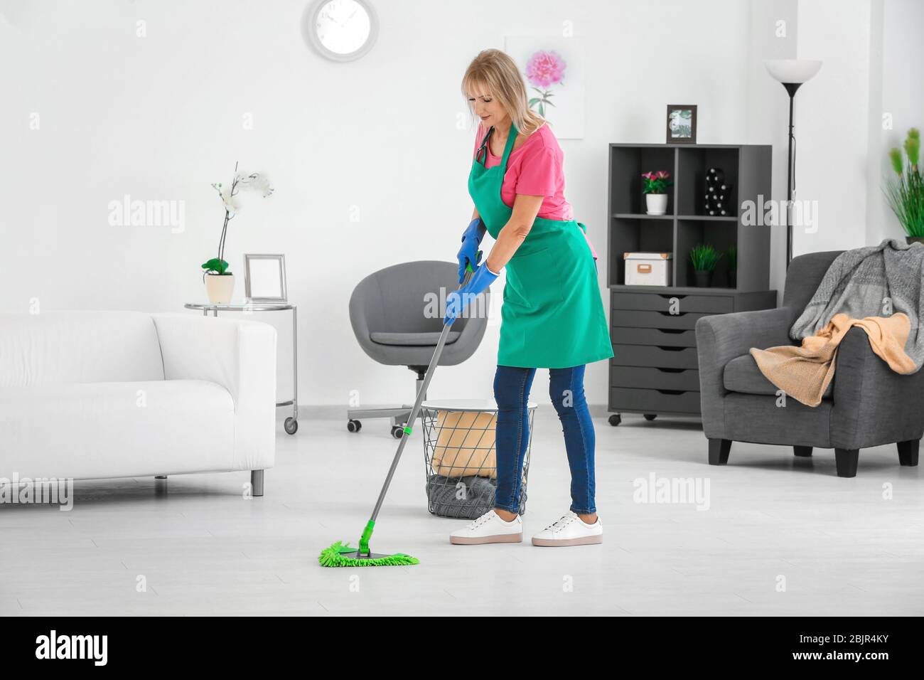Mature woman mopping floor at home Stock Photo
