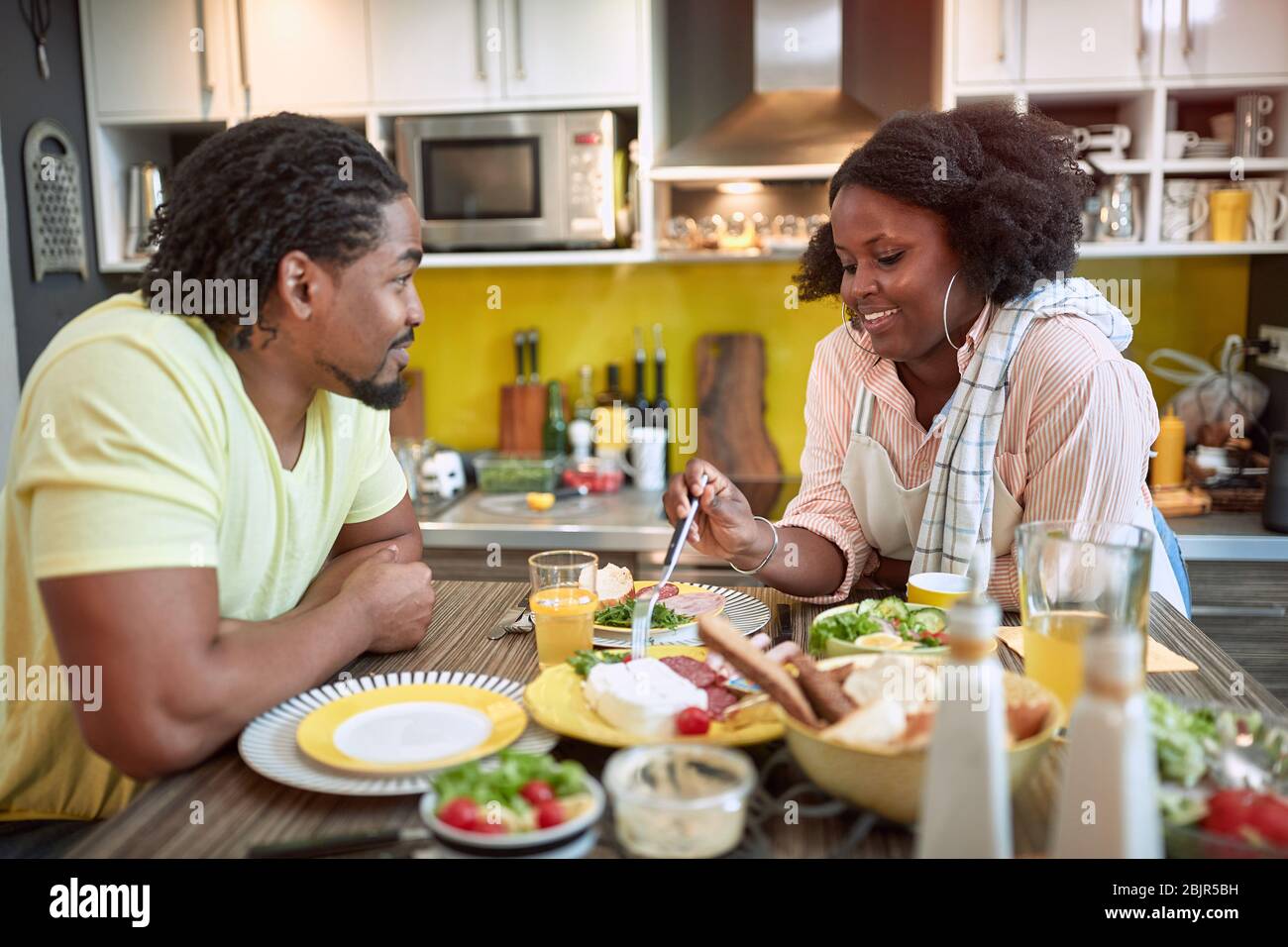 young afro-american couple enjoying breakfast together. togetherness, joy, talk, sharing meal Stock Photo