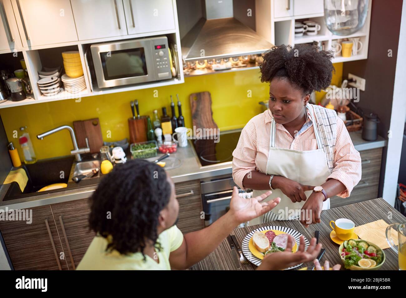 young afro-american couple arguing about being late at dinner Stock Photo