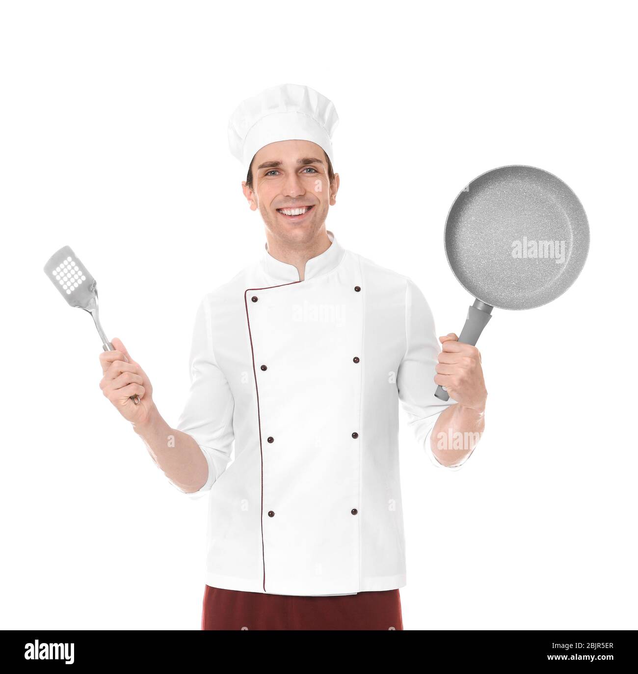 Young male chef with frying pan and spatula, isolated on white Stock Photo