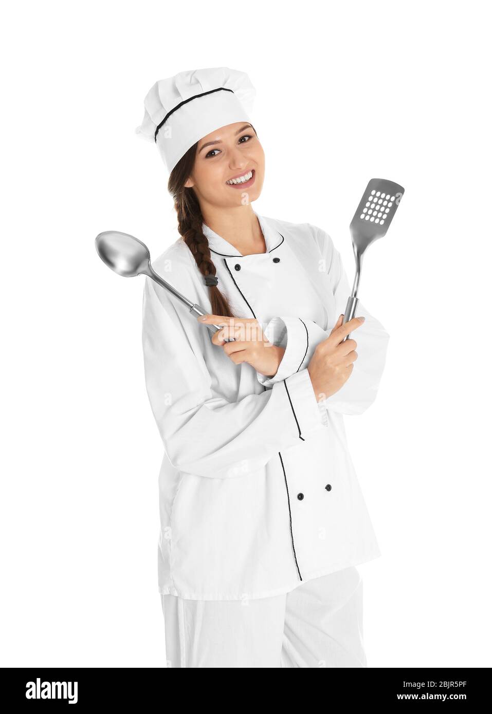 Young female chef with spoon and spatula, isolated on white Stock Photo