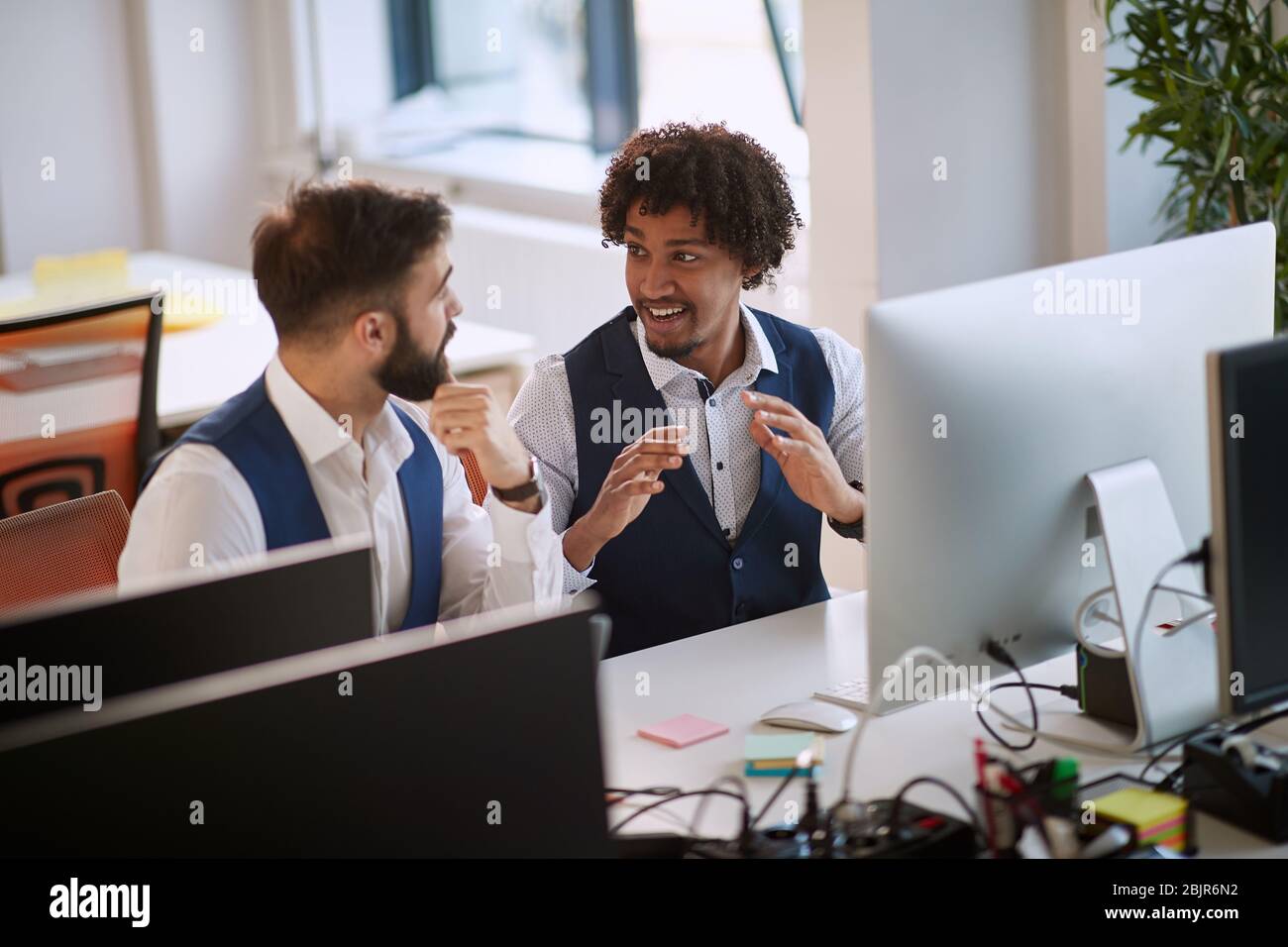 colleagues exchanging opinion at work in office. multiethnic, conversation, business concept Stock Photo
