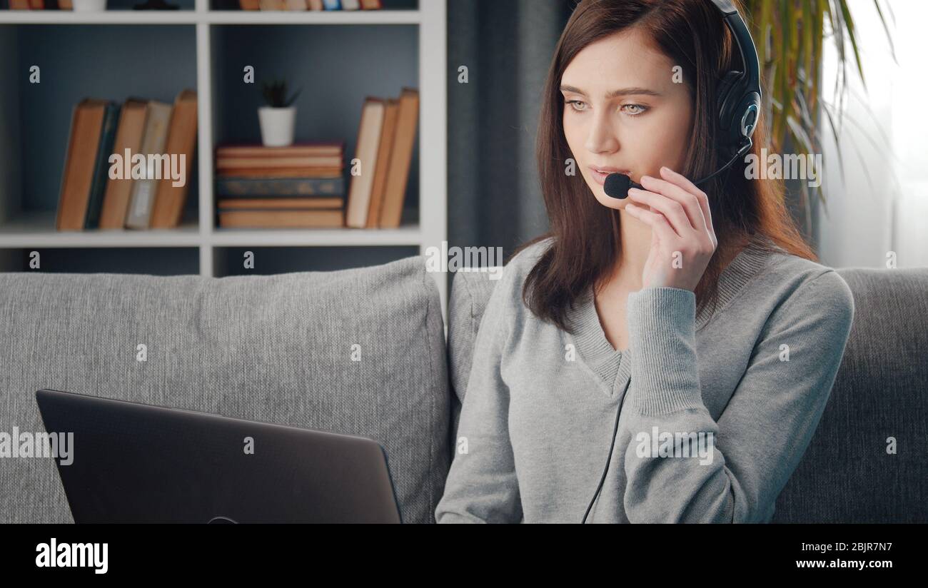 Female using laptop and headset Stock Photo