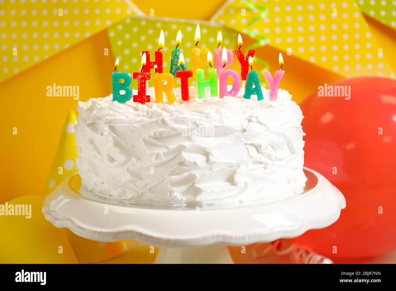 Cake with "Happy birthday" candles on stand Stock Photo - Alamy