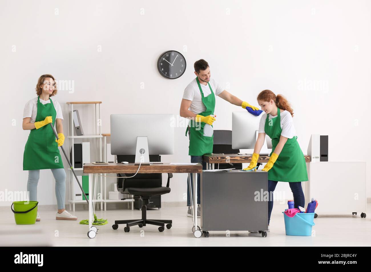 Team of young cleaning service professionals at work in office Stock ...