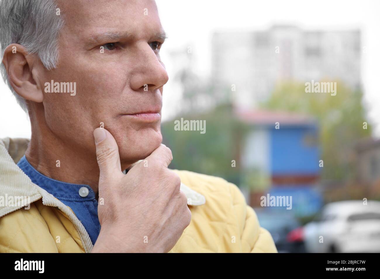 Charismatic thoughtful senior man outdoors Stock Photo