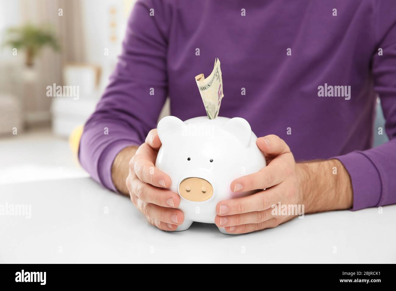 Man holding piggy bank with money, closeup Stock Photo - Alamy