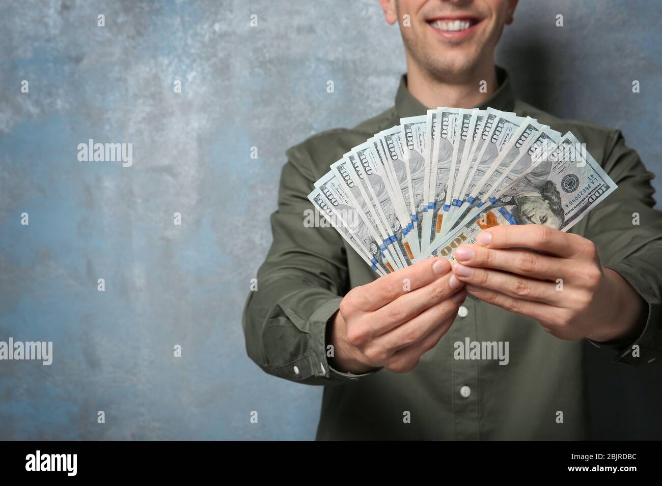 Happy young man with banknotes on grunge background Stock Photo - Alamy
