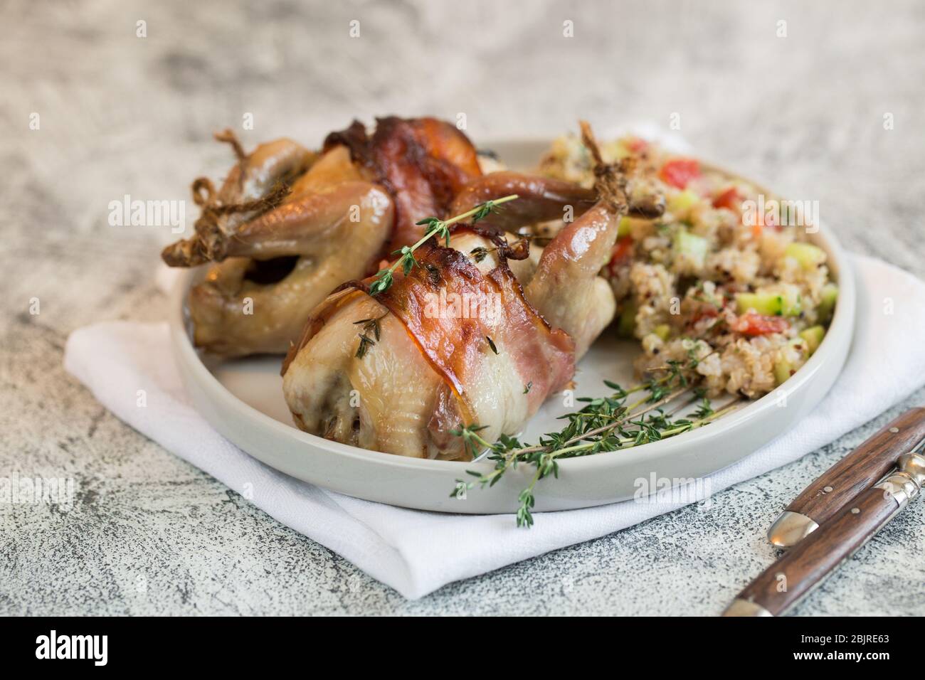 delicious baked quail with bacon and side dish Stock Photo Alamy